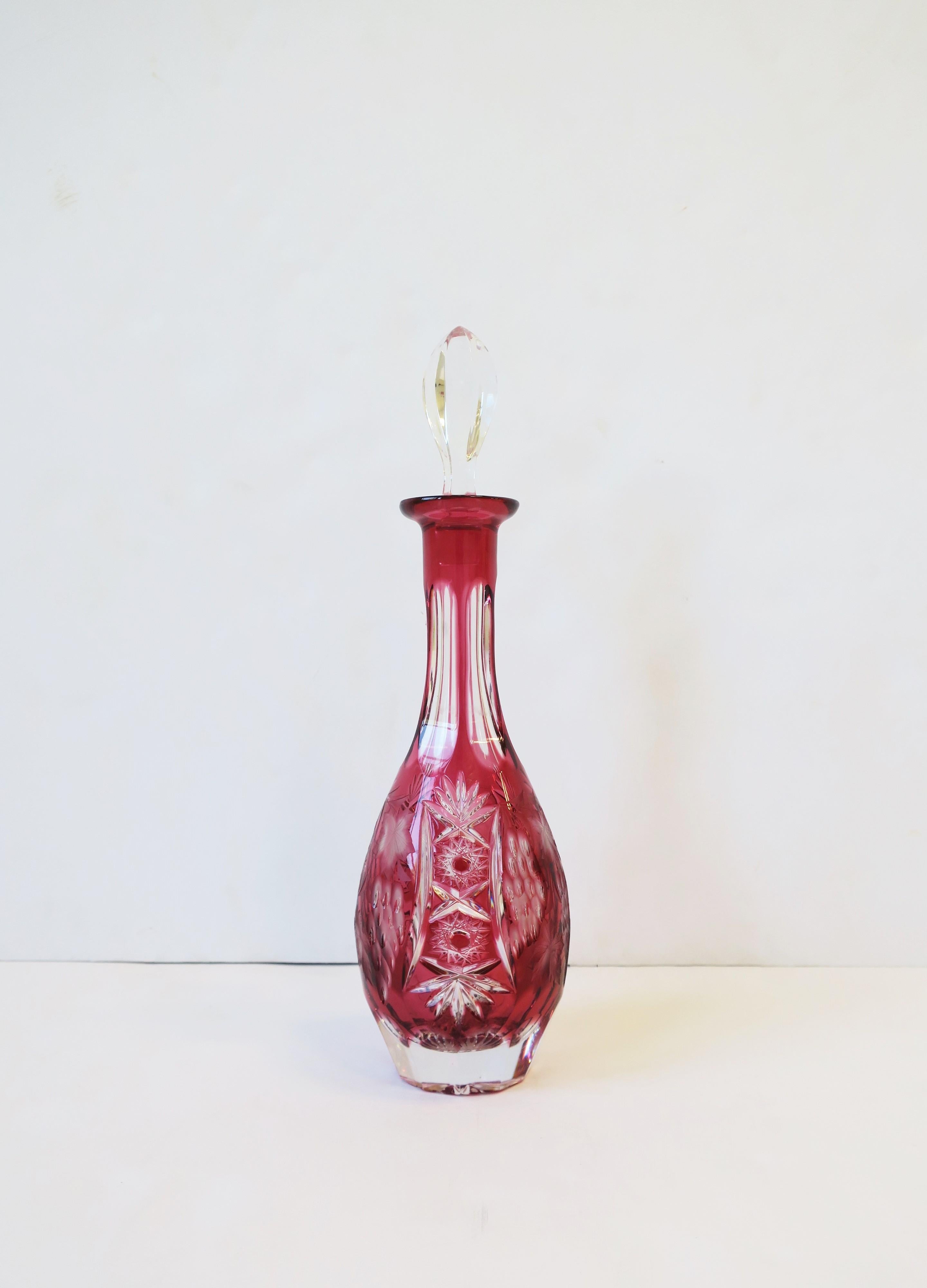 Une belle et substantielle carafe à liqueur en cristal rouge framboise rose foncé taillé et transparent avec bouchon en cristal, dans le style du fabricant de luxe Val St. Lambert, vers le milieu ou la fin du 20e siècle, Allemagne de l'Ouest,