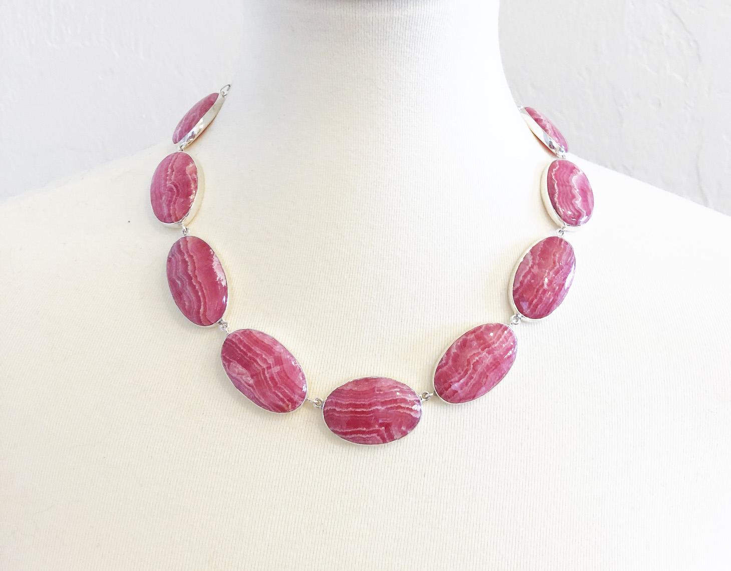 Beautiful one of a kind natural rhodochrosite bib statement necklace made with top grade cabochons that were individually bezel set in sterling silver. The large rhodochrosite cabochons range in size from 32mm x 30mm to 30mm x 30mm. The sterling