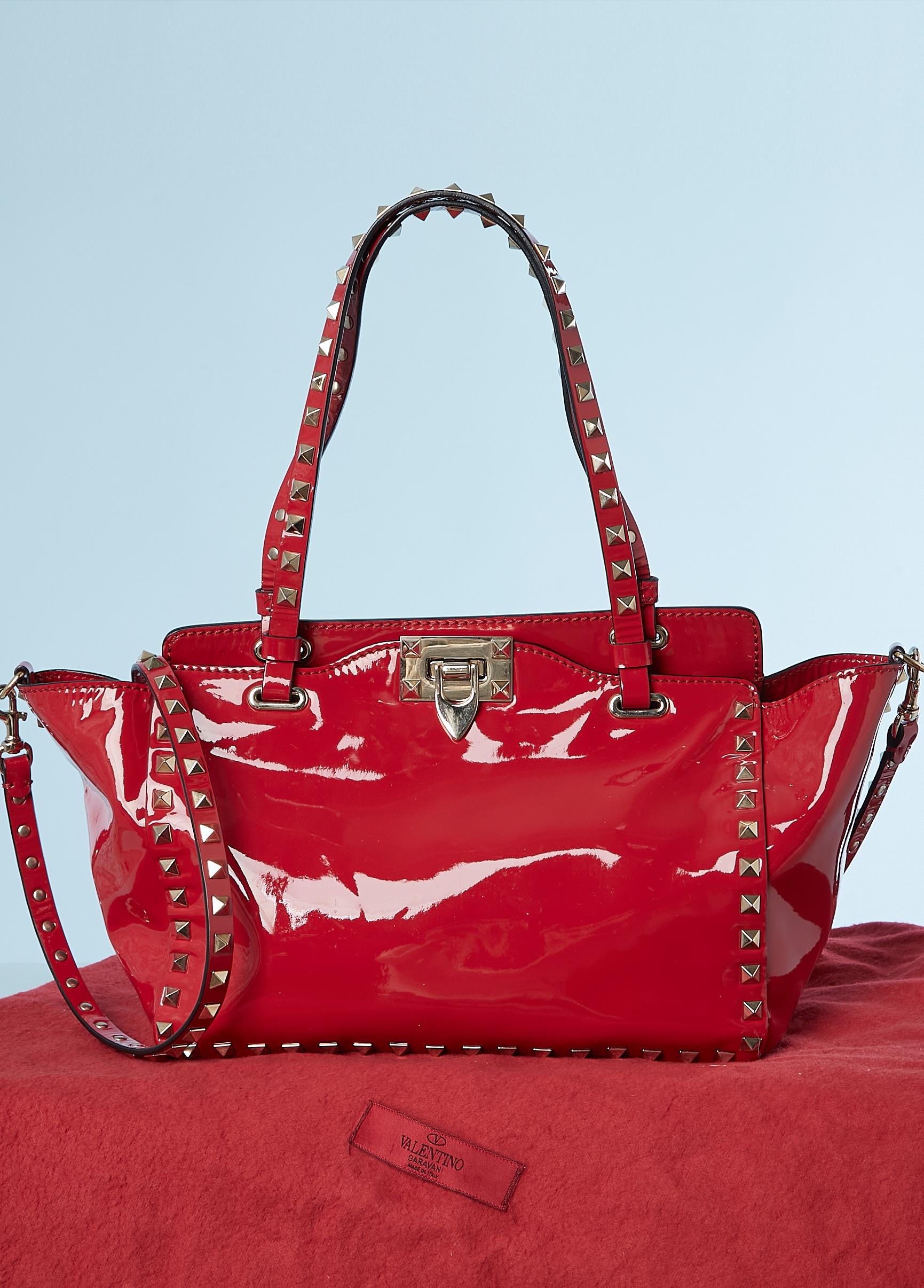 Red Rockstud Tote patent bag . Detachable shoulder strap. Cotton lining. One inside pocket with zip. 
SIZE 17 cm (height) X 26 cm ( width) X 10 ( depth)