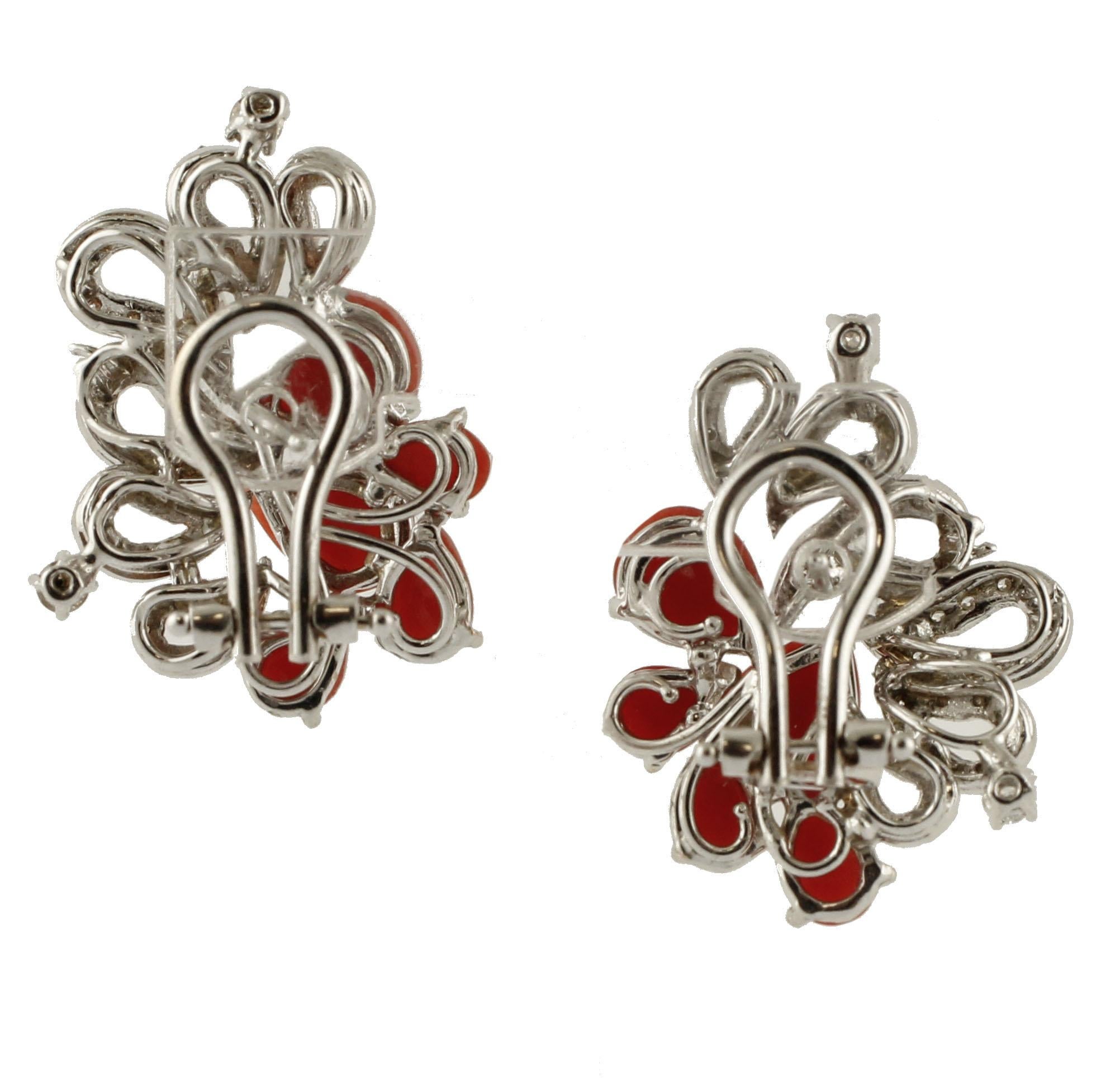 Very elegant and refined earrings realized in 14 kt white gold structure. The earrings are mounted with 5 small drop-shaped red rubrum corals adorned by drop-shaped details in 14k white gold studded with diamonds. 
These earrings are totally