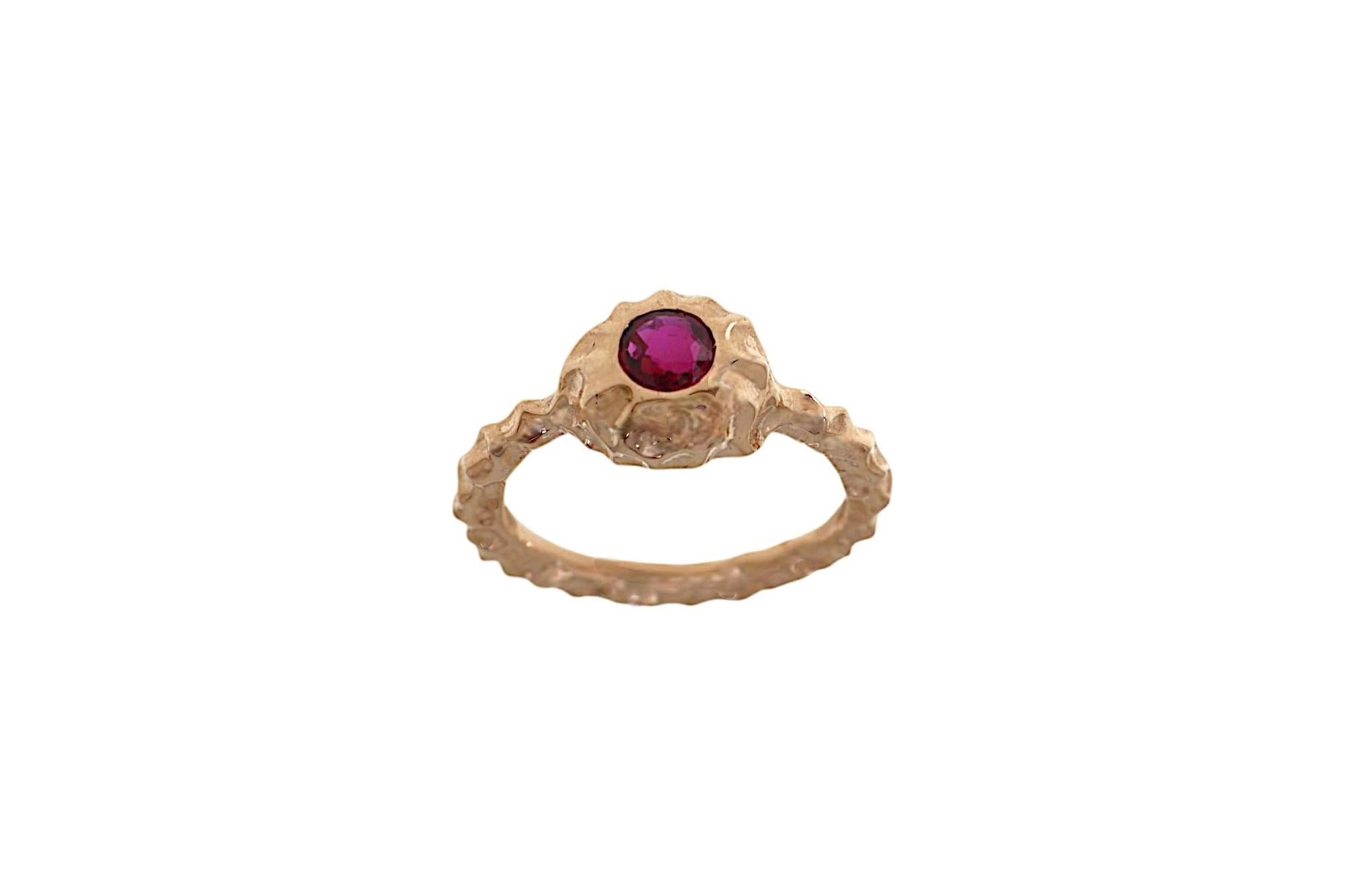 Handcrafted ring in 9k rose gold, made in our goldsmith workshop in Milan. The solid gold band has been meticulously handworked to create this rock-like texture, making each ring one of a kind. At its center, a natural round ruby of 0.45 ct has been