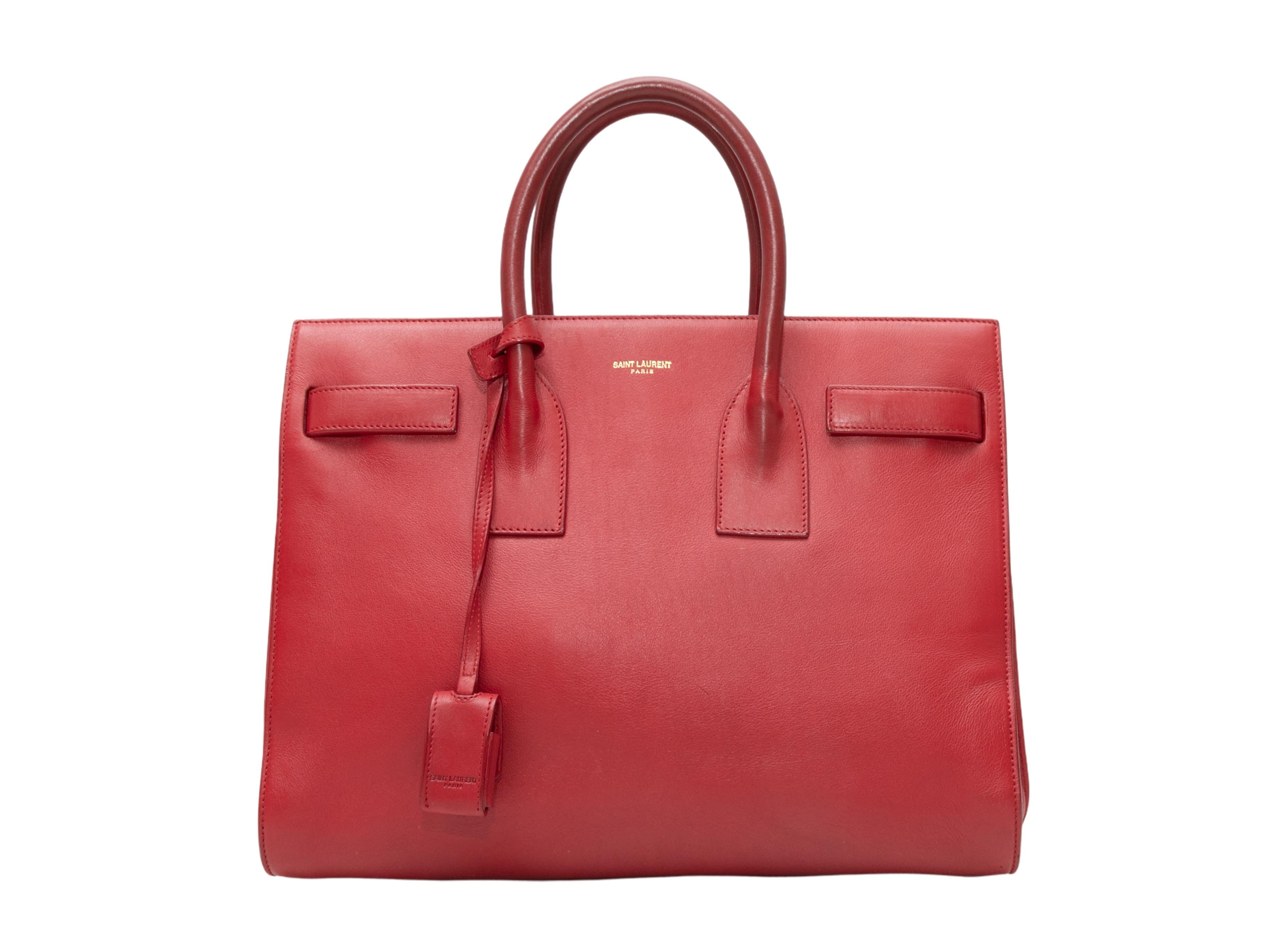 Red Saint Laurent Small 2014 Sac du Jour Bag. The Sac du Jour Bag features a leather body, gold-tone hardware, dual rolled top handles, optional flat shoulder strap, and a top zip closure. 12.25