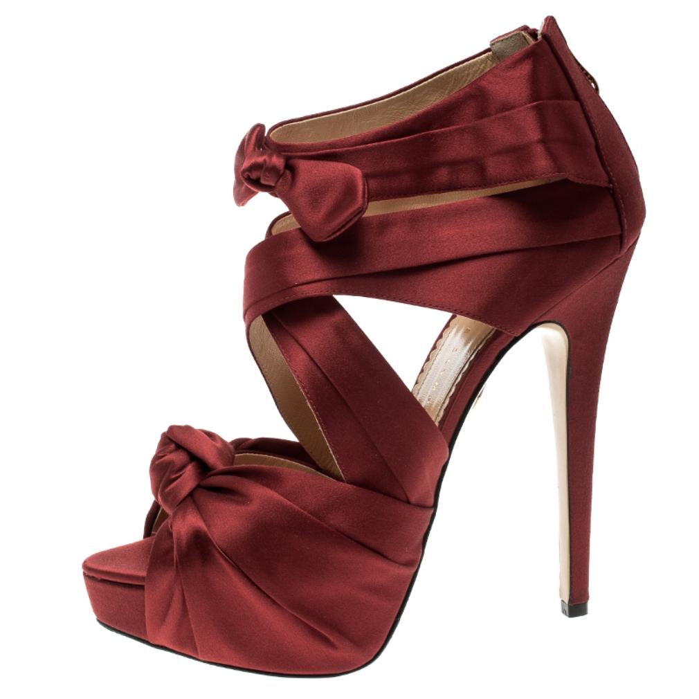 These Charlotte Olympia platform sandals are exactly what you need to glam up your party outfits. These sandals feature crossed satin straps in a bold shade of red which are beautifully knotted on the vamp and the ankle strap. The look is completed