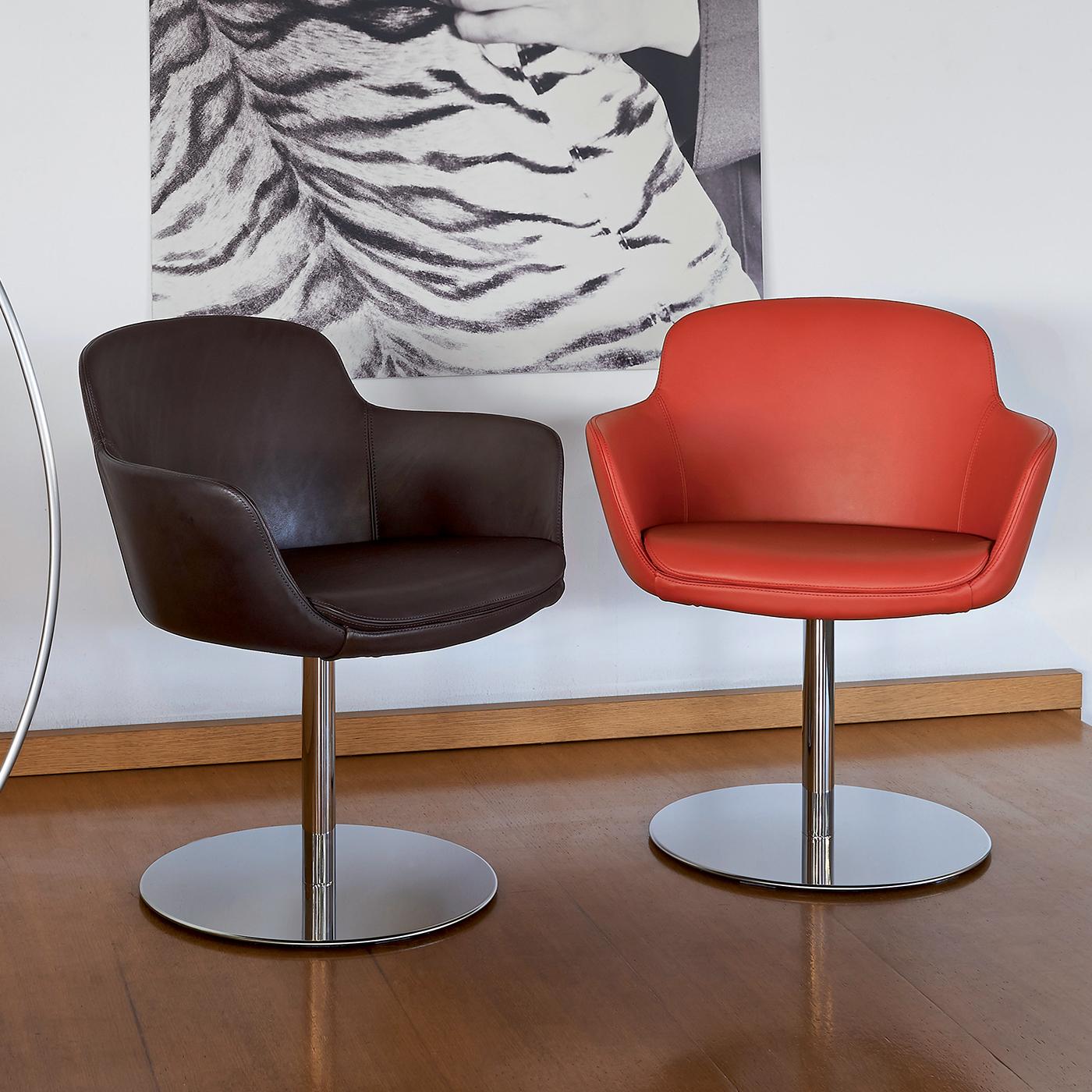 Upholstered in bold red leather, the Sella Swivel Chair stands out for its unique and chic shape, both in private homes and public spaces. The seat is upholstered in completely removable leather, allowing for easy cleaning, held together by