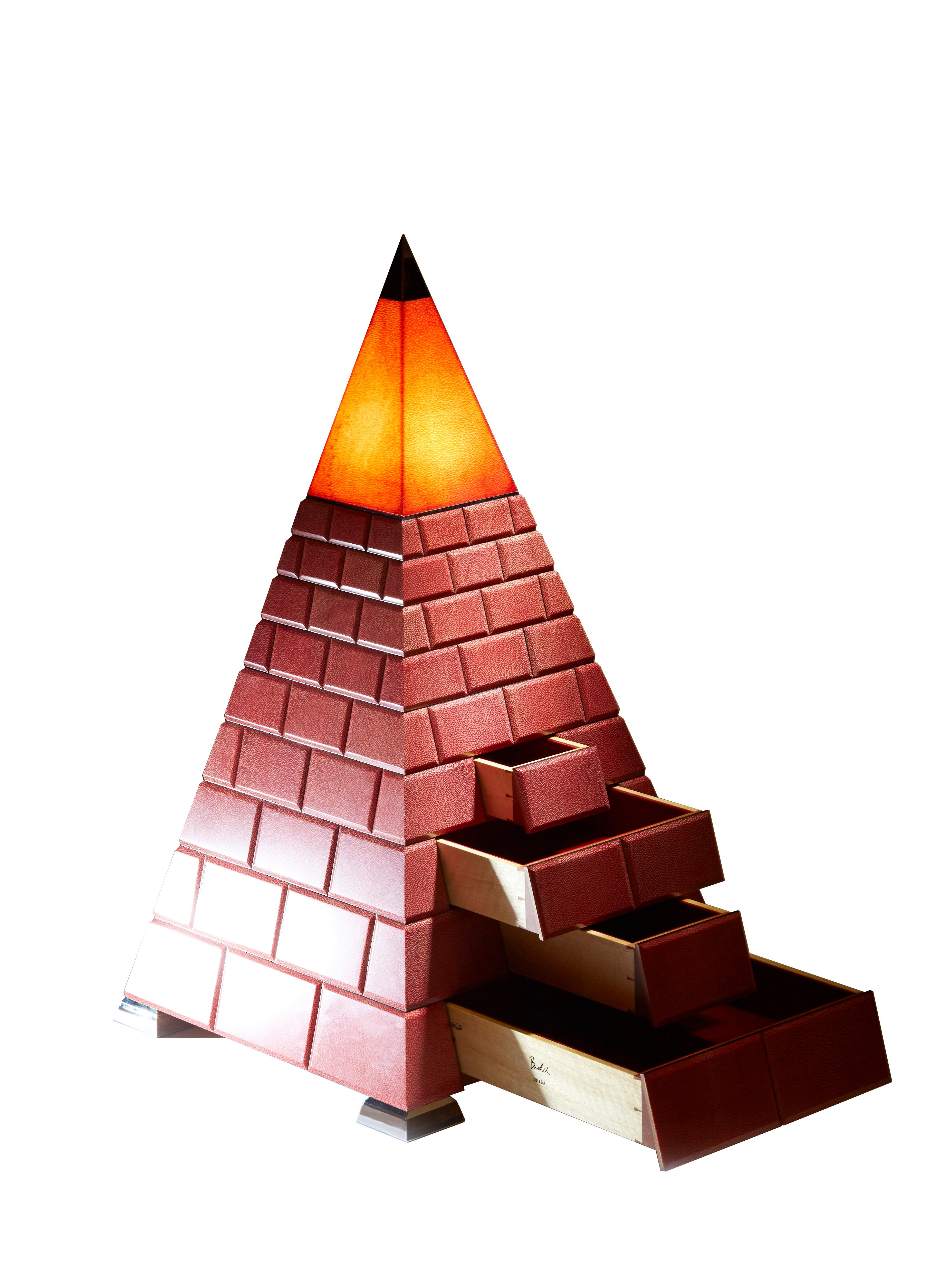 Il design Art Déco ha le sue origini nel periodo faraonico dell'antico Egitto. Il mistero e il fascino esotico di questo periodo iconico sono stati la nostra ispirazione per questo pezzo molto speciale. I pannelli di zigrino illuminati ricreano