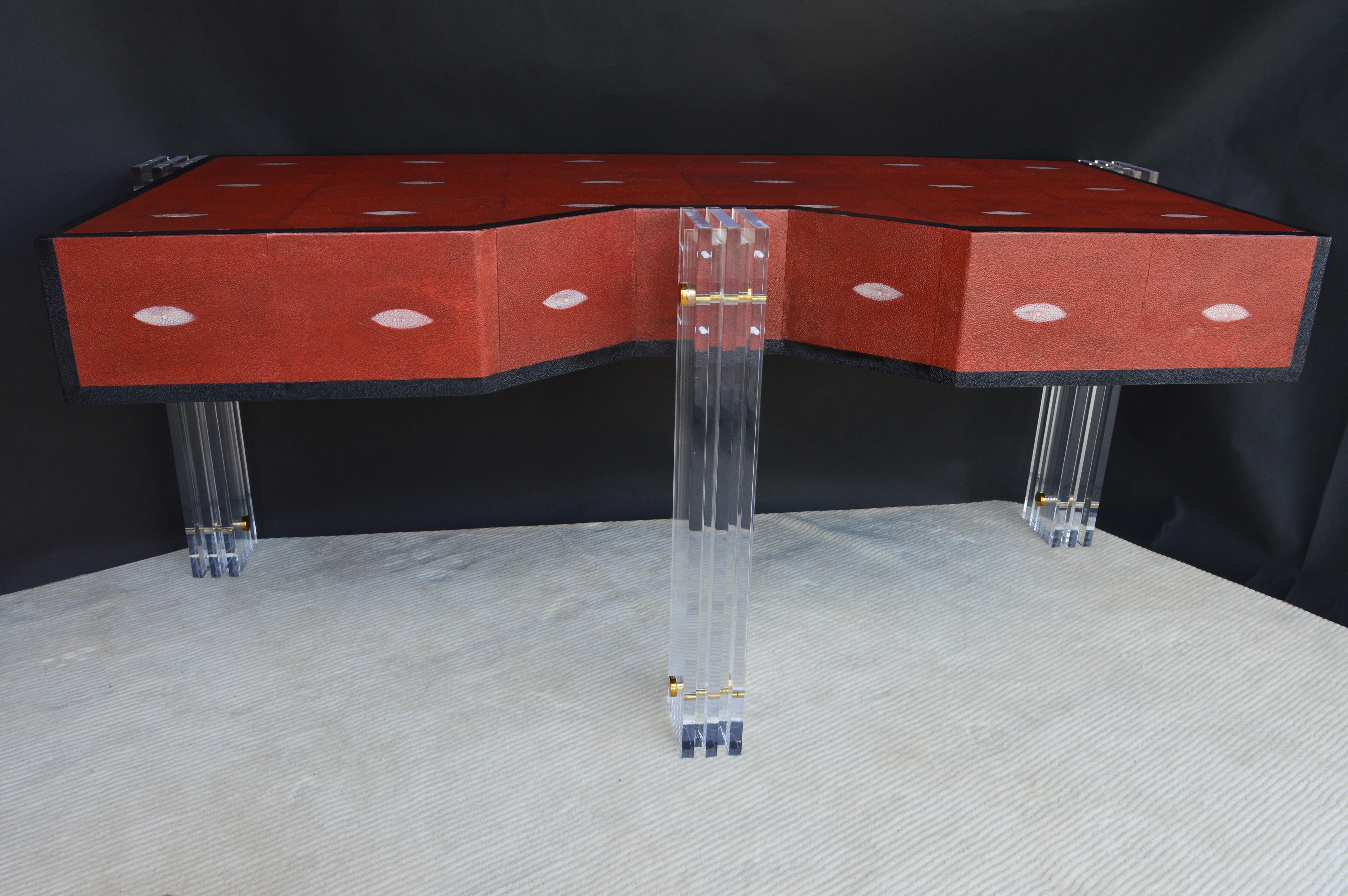 Red, with black edges shagreen desk. With Lucite legs and brass hardware.