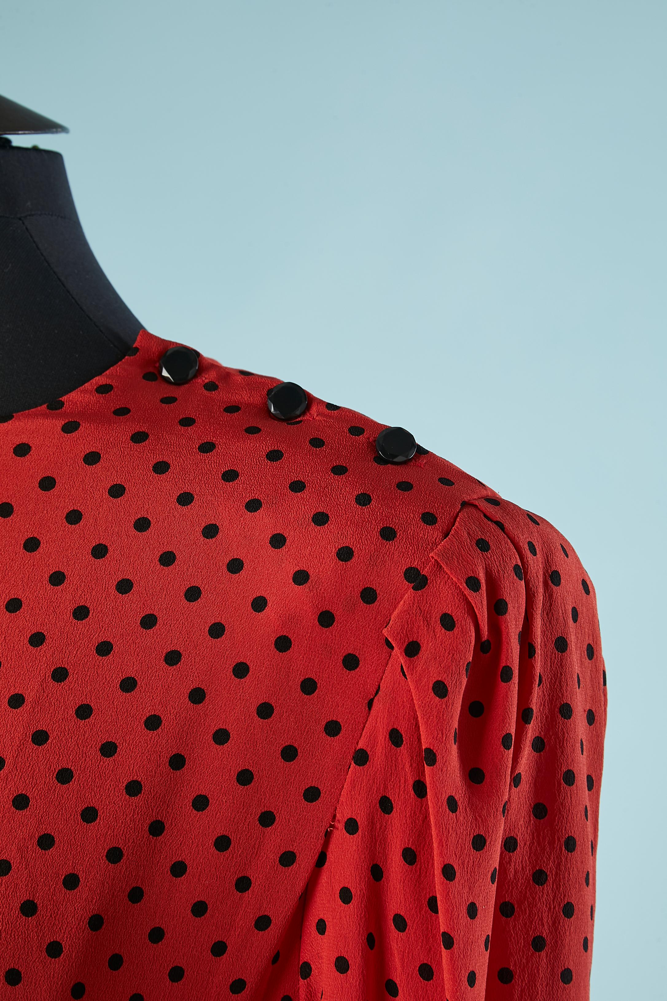Red silk top and skirt ensemble with black Polka dots. Black buttons on the left side of the top and the skirt. Fabric buttons on the cuffs. Shoulder-pad. Cut-work on the waist. 
Size S 