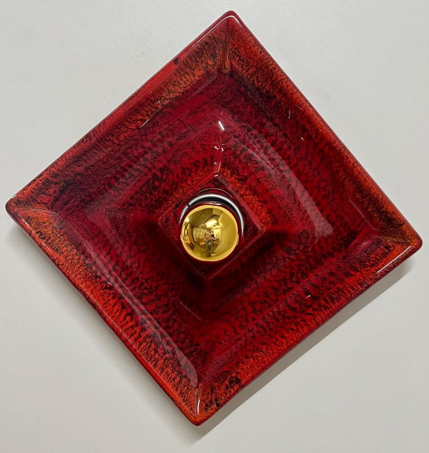 Luci da parete in ceramica rossa. Prodotto da Hustadt Leuchten Keramik, Germania, negli anni Settanta.

Lo smalto è rosso e ha una forma quadrata.

Noi abbiamo utilizzato lampadine a specchio dorate (vedi immagini), ma anche le lampadine a specchio