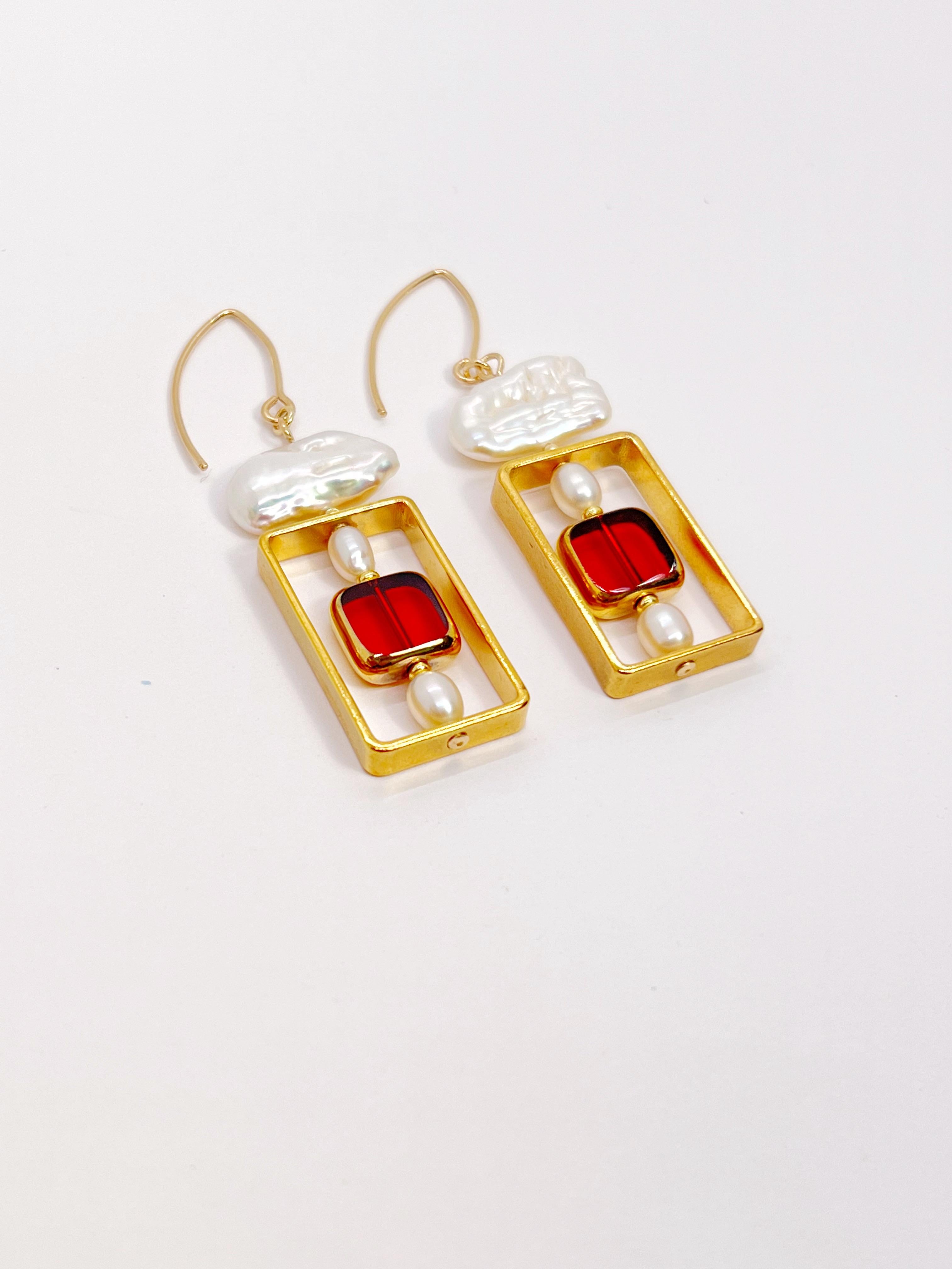 The earrings are lightweight and may rotate and reposition with movement.

The earrings are composed of a red square translucent German glass bead and complemented by freshwater pearls. They are new-old-stock vintage German glass beads framed with