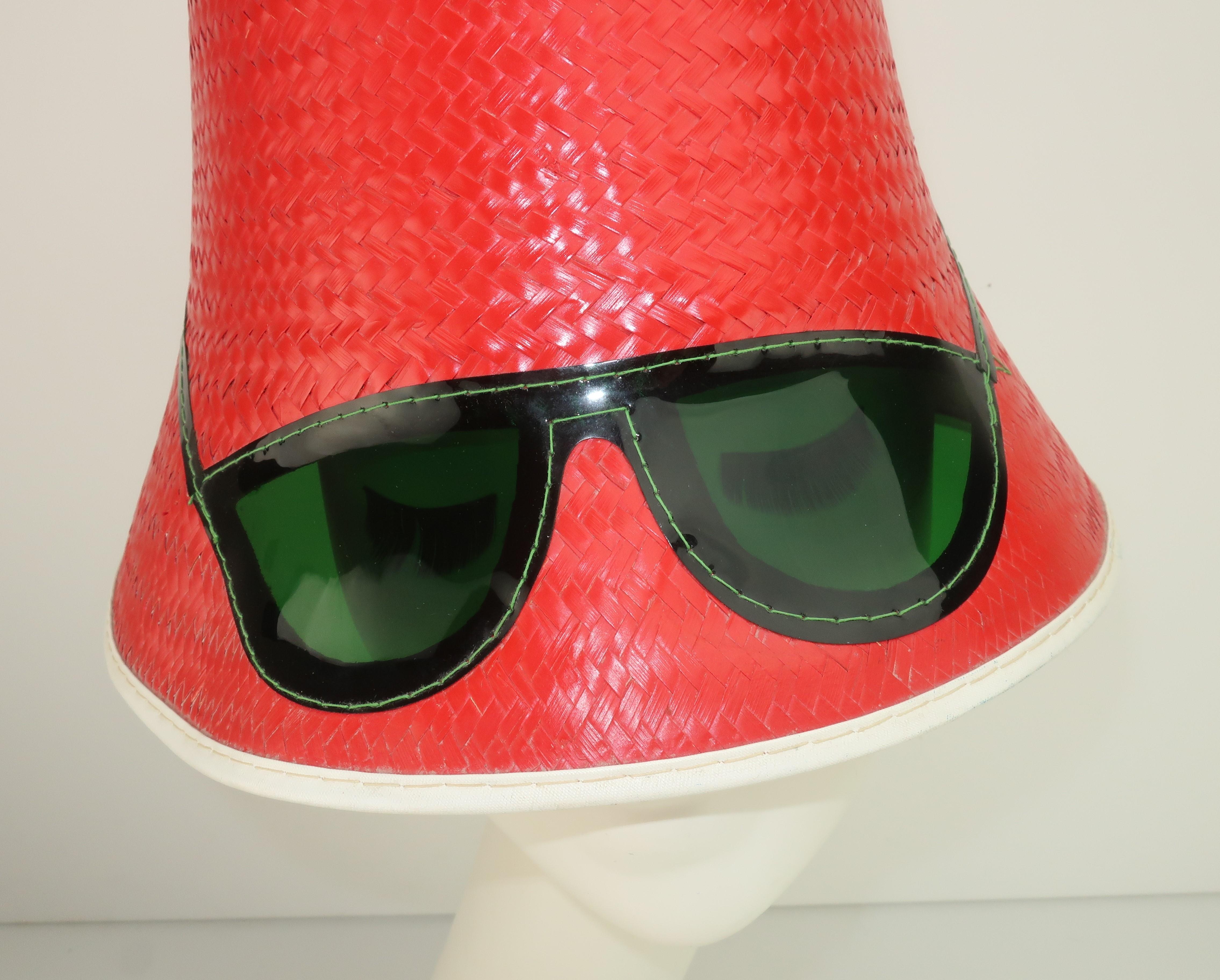 Mod und Wunderbar!  Nicht zu vergessen:: auch praktisch!  Ein lustiger roter Strohhut aus der Zeit um 1960 mit einem unerwarteten:: skurrilen Touch einer dunkelgrünen Sonnenbrille.  Das Detail auf der Silhouette der Cat-Eye-Shades erstreckt sich bis