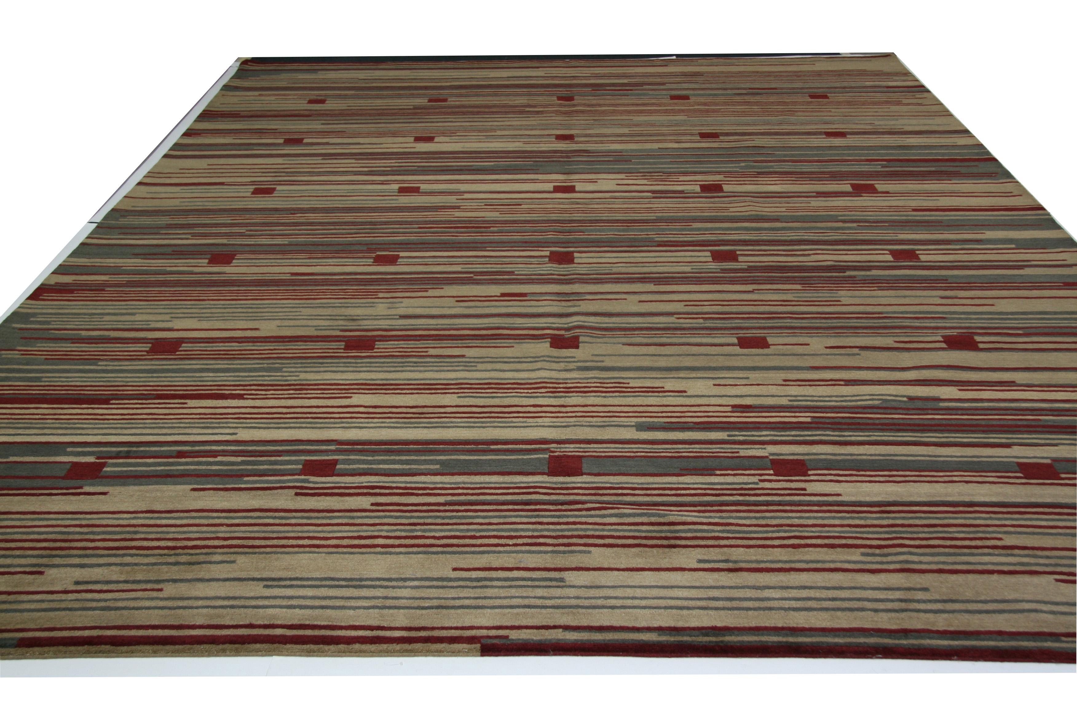 Des carrés rouges sur un fond de rayures beiges, rouges et grises constituent la bonne dose d'audace dans un tapis qui peut attirer l'attention sans nuire aux autres aspects de l'espace. Noué à la main au Népal avec de la laine teintée avec des