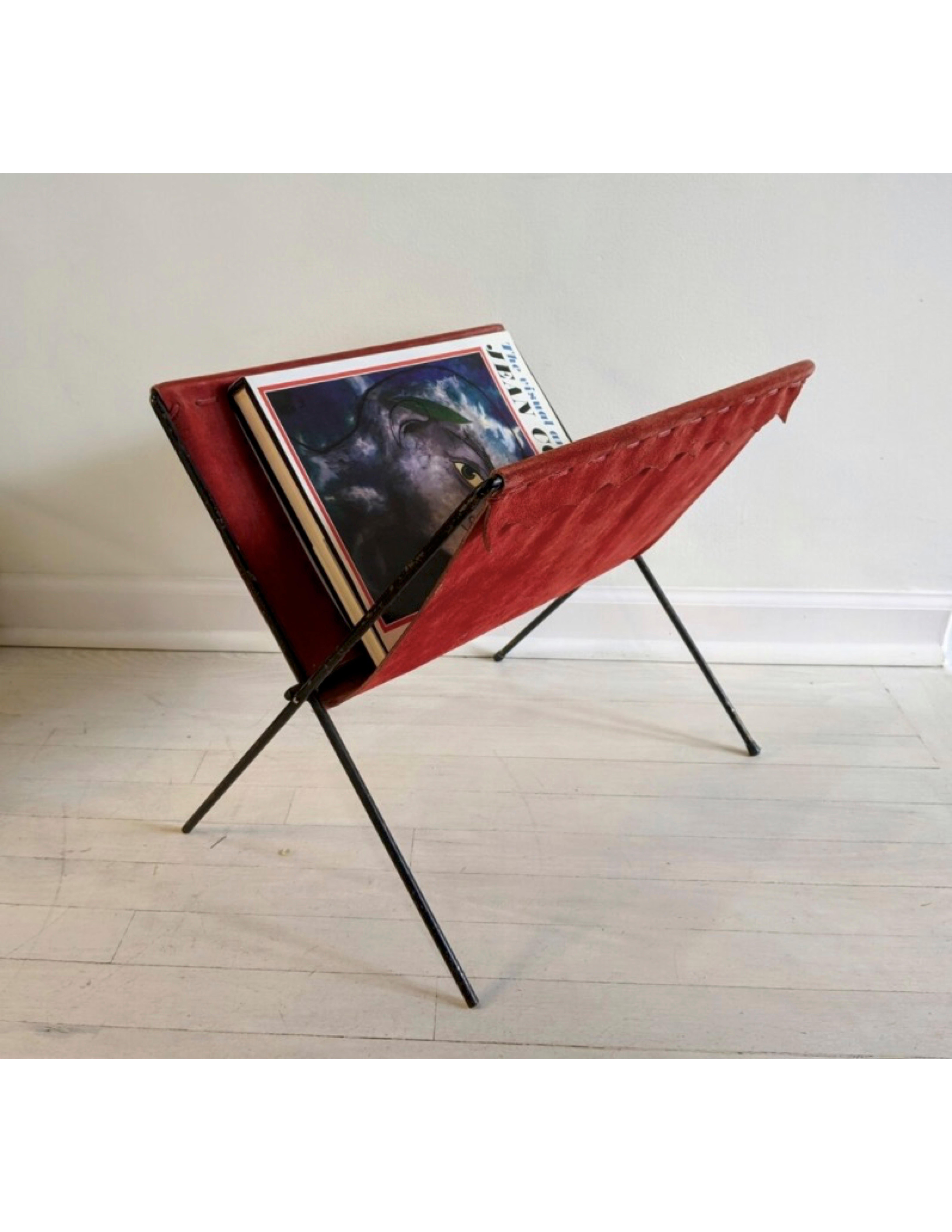 Foldable vintage magazine/book rack made out of red suede and black iron frame. Weave and scallop detail along top edge. Sourced in France.