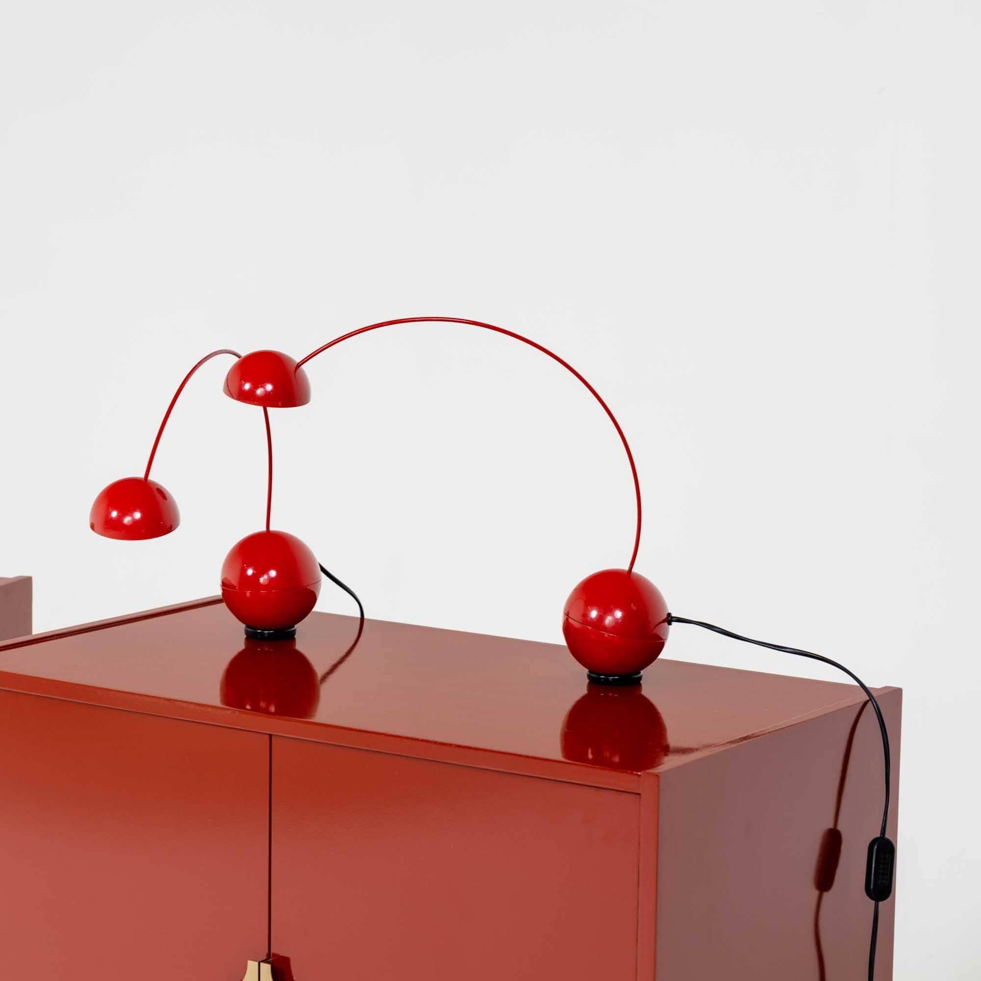 Pair of red table lamps with spherical bodies, attributed to the Italian company Valenti. Crafted from red enamel painted metal. The table lamps are weighted and stand on a disc-shaped magnet, allowing them to be rotated at will.