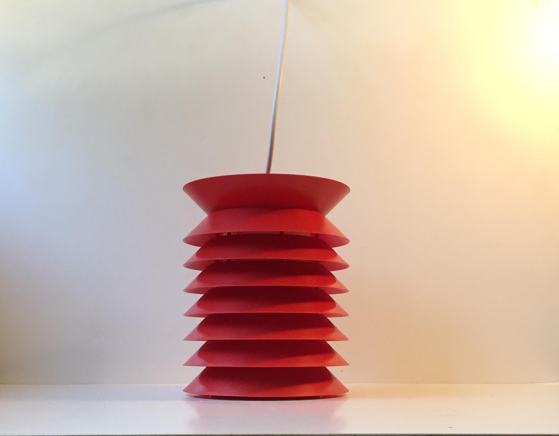 Red seven-tiered pendant lamp composed of plastic and a white light reflective acrylic tubular inner shade. The light features its original brass and porcelain socket. It was manufactured by Høyrup Lights in Denmark during the 1970s. This design by