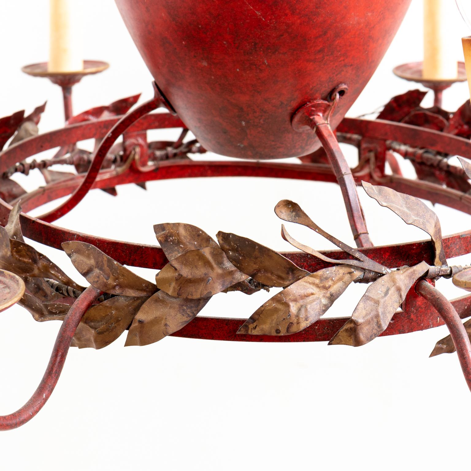 Circa 1970s red painted six arm chandelier in the French Provincial style with gilt decoration and a wreath of metal laurel leaves in a patinated finish. The chandelier is a reproduction from the 1970s and features other Neoclassical motifs such as