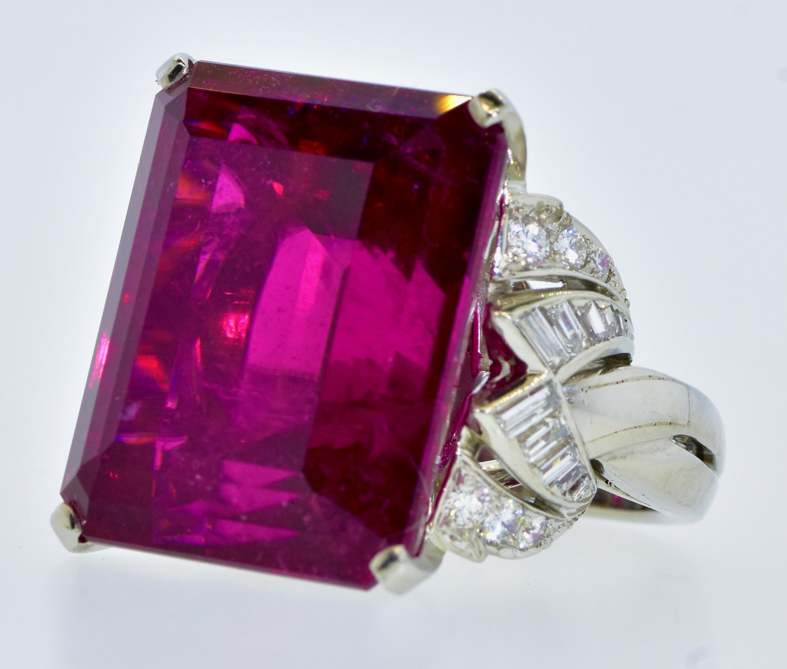 This vintage ring centers a natural rubellite (red tourmaline) weighing an estimated 38.5 cts., and measuring 20.8 mm. by 16.85 mm by 12.75 mm.  In terms of inches, this emerald cut stone measures about 13/16 inches (a bit more than three quarters
