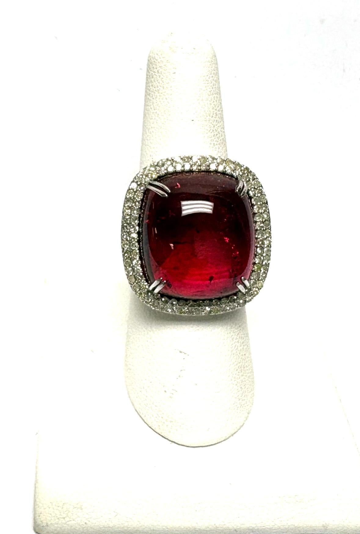 Description
An exceptionally gorgeous, deep red tourmaline cabochon, ablaze with brilliance, is encircled by a double-step diamond setting. Supported by an open basket adorned with diamond-set sides. A ring  that exudes depth, radiance, and refined