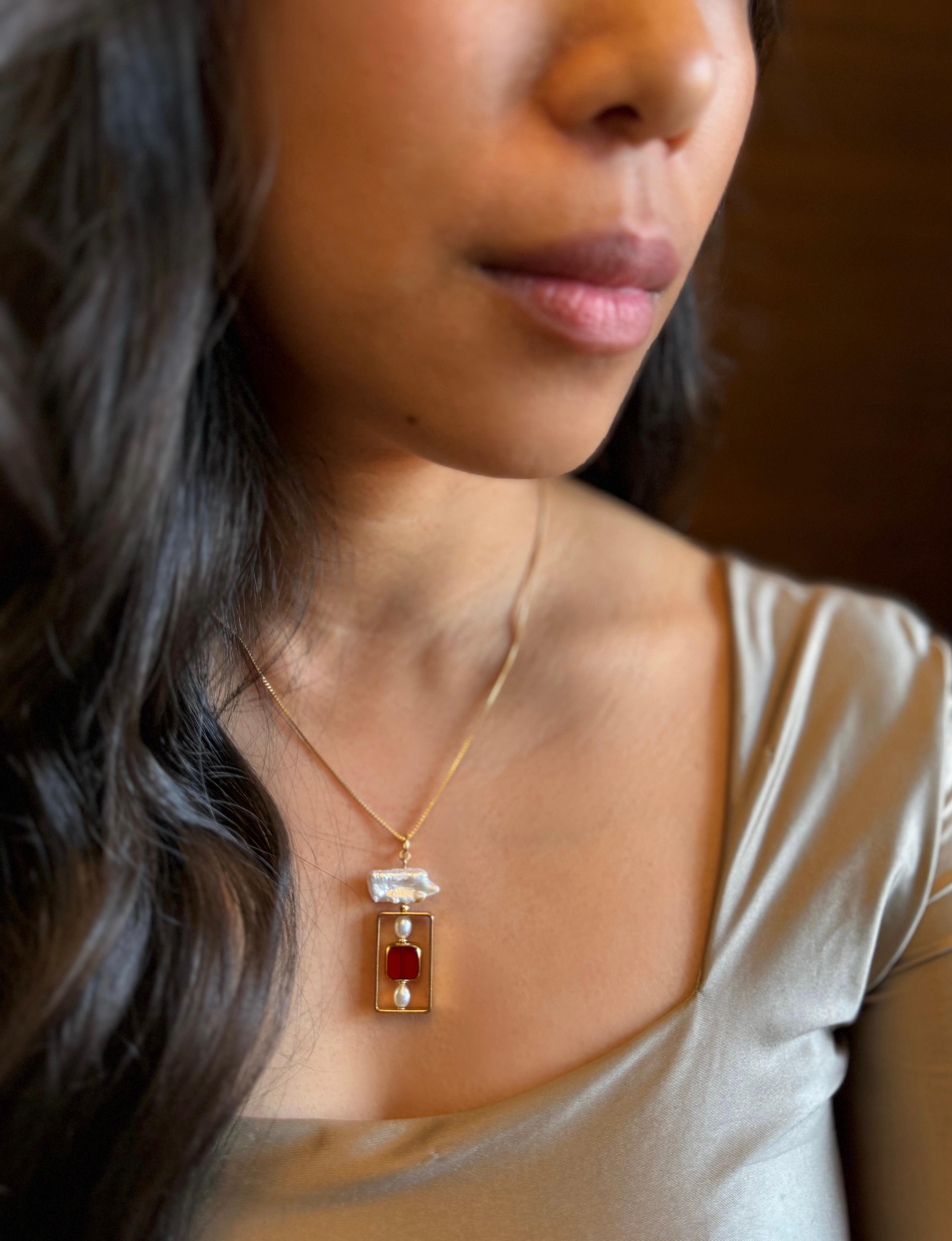 The necklace is composed of German Vintage Glass Beads that are edged with 24K gold. It is incorporated with freshwater pearls set in a rectangular geometric frame with an 18-inch gold-fill chain.

The vintage glass beads that are framed with 24K