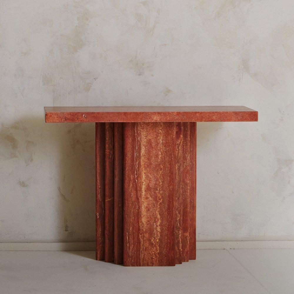 A Mid Century Italian console table constructed with honed red travertine featuring stunning veining in a range of red and orange hues. This table has a rectangular top which rests on an architectural base with a tiered design. Sourced in Italy,