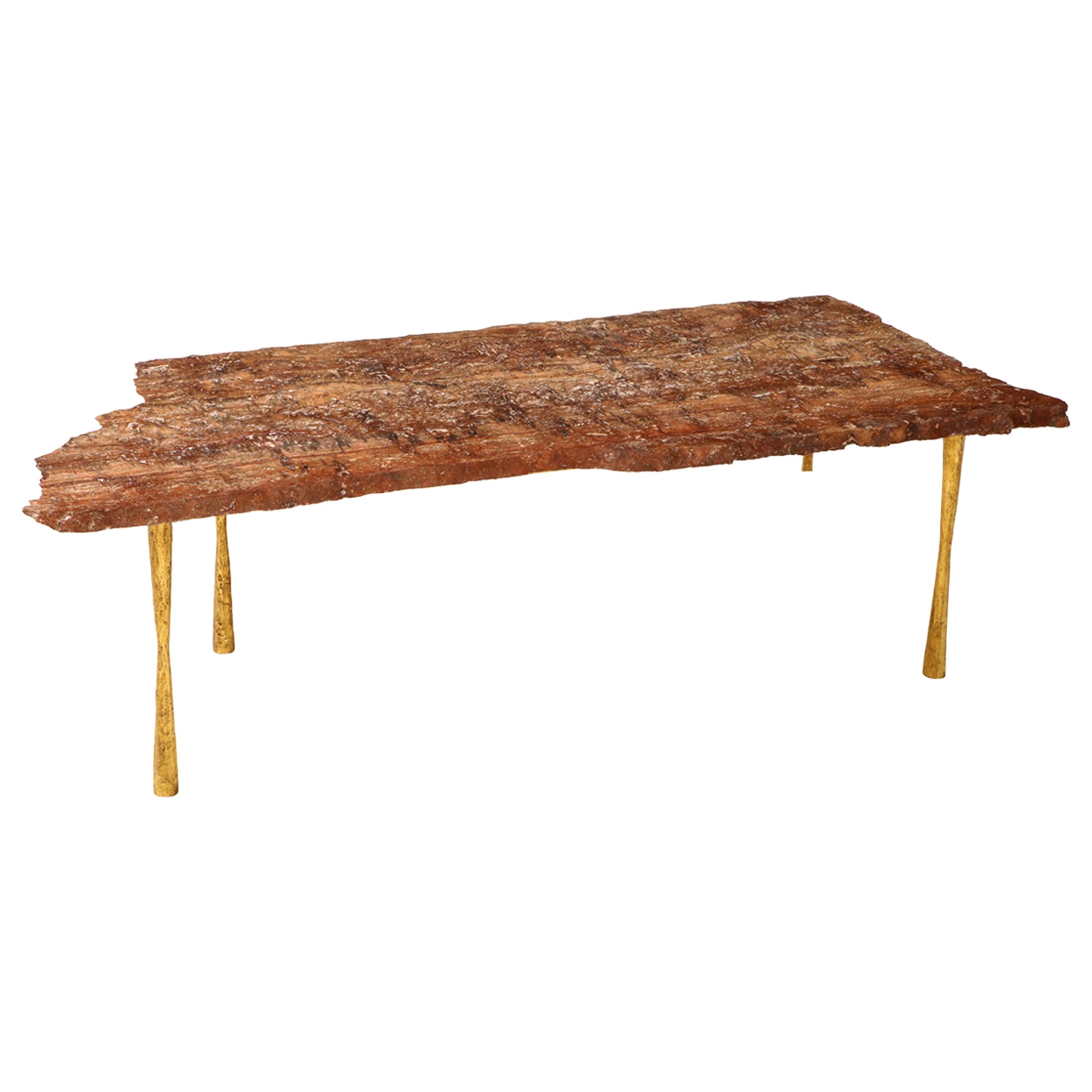 One of a kind, hand-made rockface edge (raw edge) red travertine stone top coffee or cocktail table with aged, 24-carat gold leaf iron legs. This rare red travertine stone top cocktail or coffee table was handcrafted in Italy. The natural red