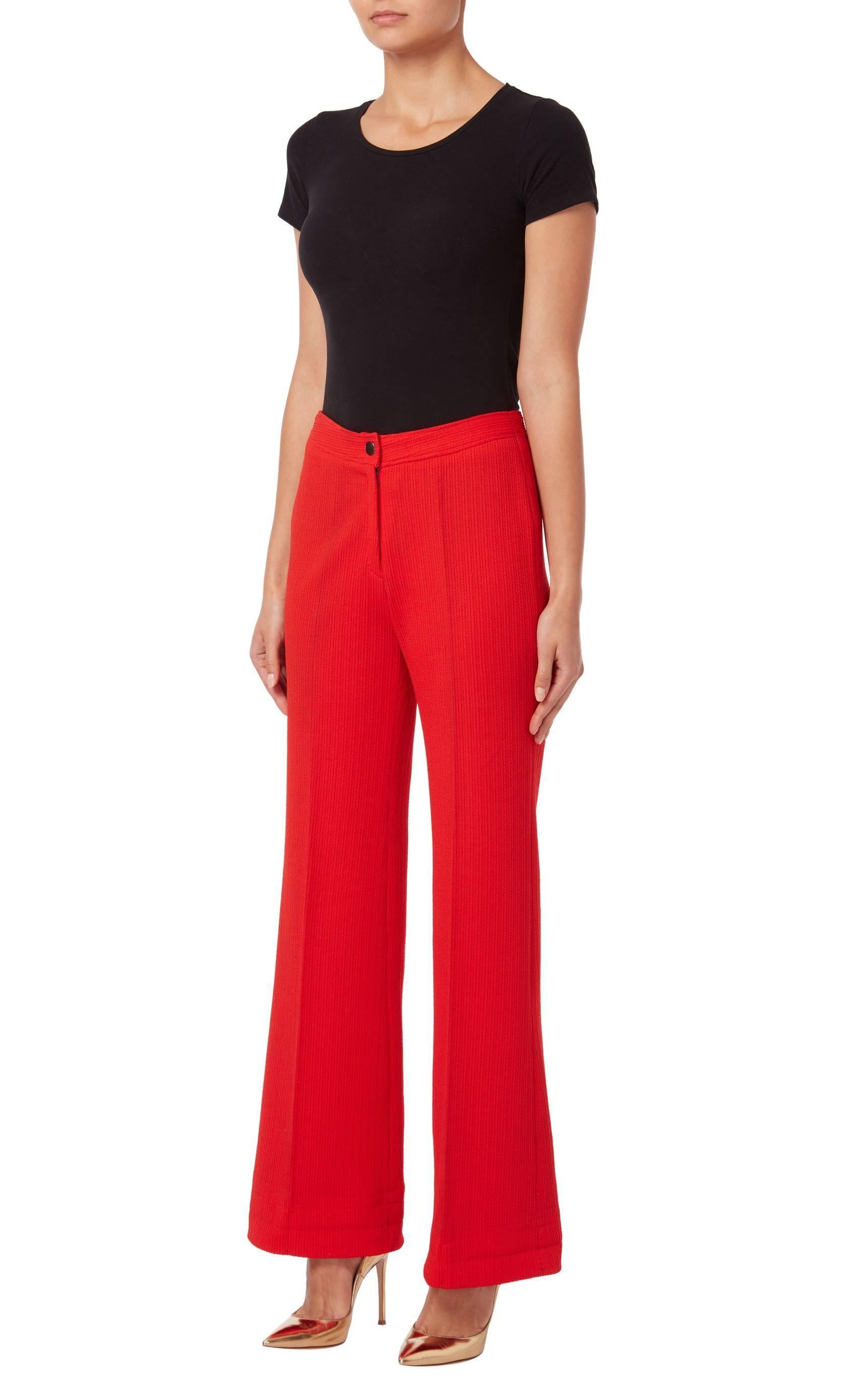 Red trousers from 1972. The trousers are slightly flared and are secured by one button to the waistband.