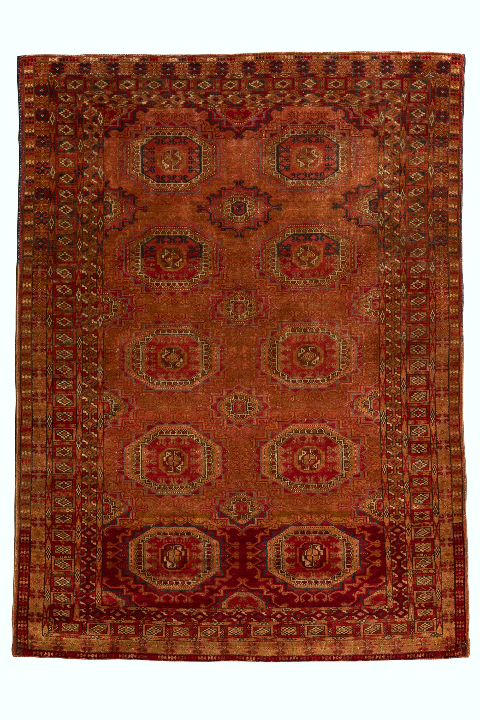 Esta alfombra turcomana, verdadera encarnación de la elegancia tribal, cautiva por su rico simbolismo y su artesanía consagrada. Esta exquisita pieza presenta los icónicos motivos gul, sello distintivo del tejido turcomano, meticulosamente