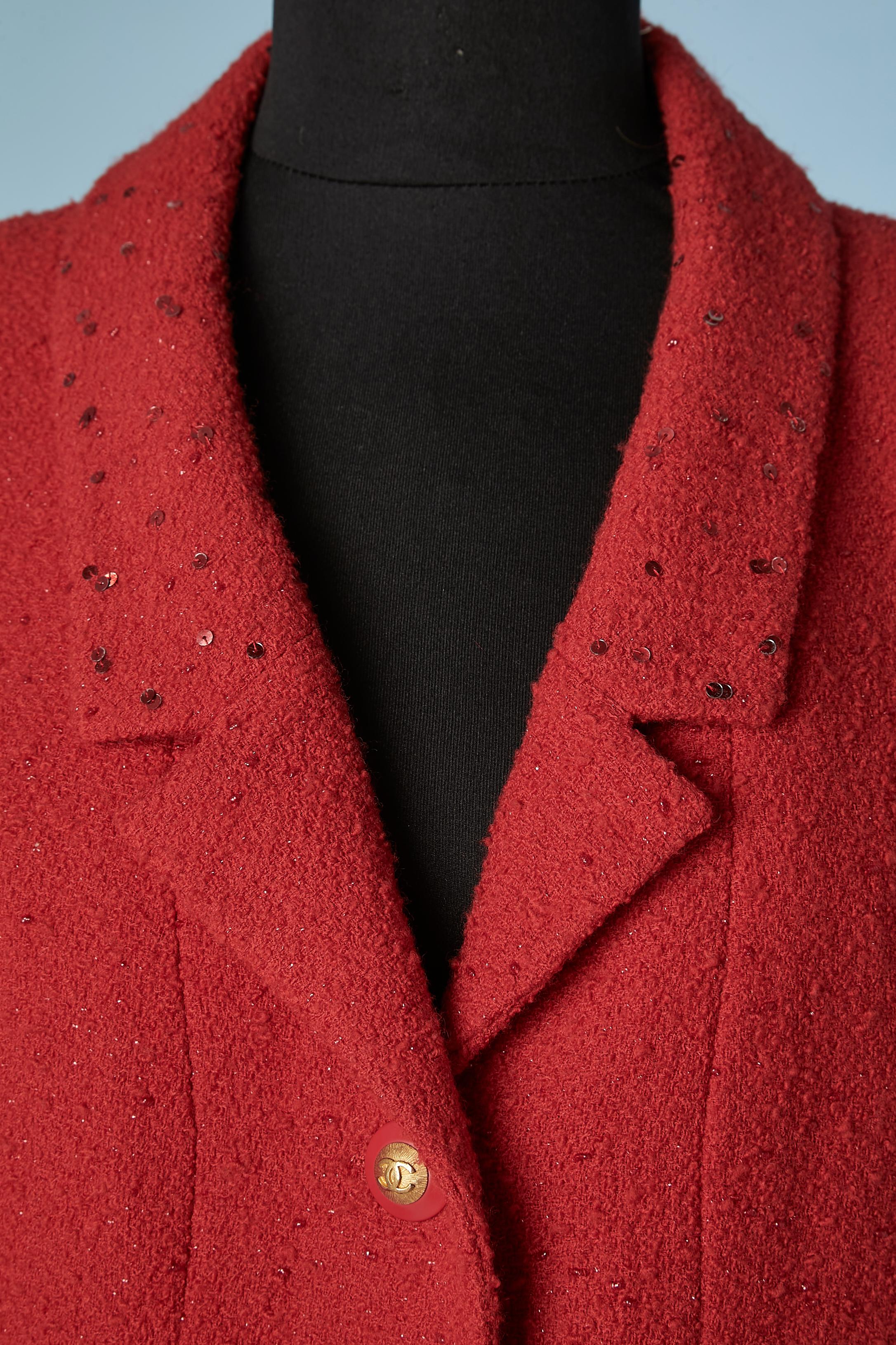 Veste croisée en tweed rouge, doublée de paillettes rouges et de soie. Boutons de la marque. Des pads d'épaule. Chaîne à l'intérieur de la jaquette sur le bord inférieur. 
TAILLE L 