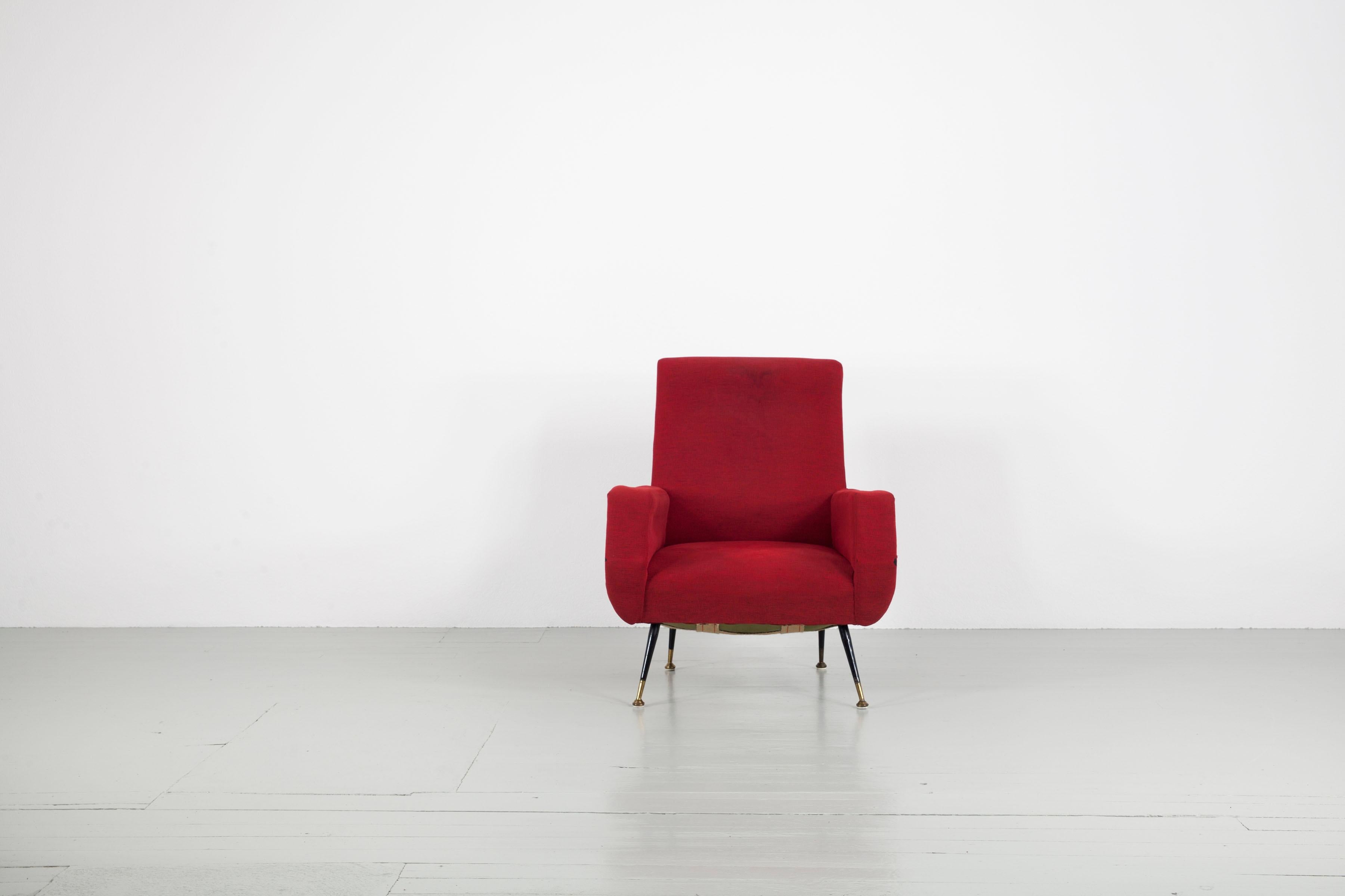 Fauteuil d'Italie, années 1950. Cette pièce est étroitement liée à la tradition de Gianfranco Frattini. Le fauteuil présente les pieds typiques en métal avec des éléments en laiton et un tissu d'ameublement rouge. Le fauteuil a besoin d'être