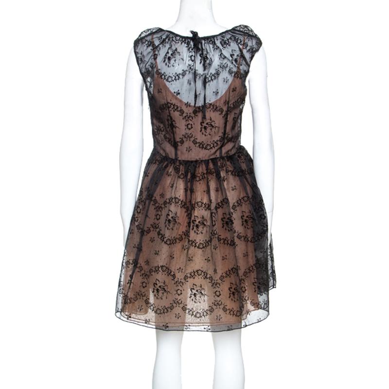 Look and feel like a diva in this superb RED Valentino dress. Crafted from a lovely blend of silk, it comes in a classic black color. It features a stunning burnout floral pattern and has a sheer quality. It has a lovely silhouette and ca be worn to