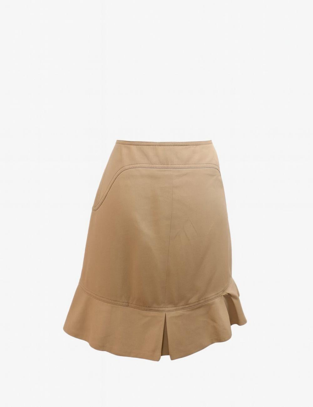 Add a playful yet sophisticated touch to your wardrobe with this Red Valentino Beige Ruffle Hem Skirt. Crafted in Italy, this skirt blends minimal tailoring with feminine details. The clean silhouette is elevated by soft seam accents and a flared