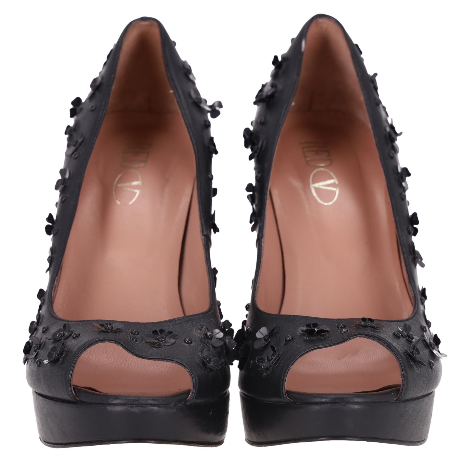 Rote Valentino Blume verschönert Leder Peep-Toe Heels

Schwarze Plateau-Pumps aus Leder, vollständig mit schwarzen Miniblumen und Perlen verziert.

Mit Peep-Toe-Design und hohem Blockabsatz.

Futter und Sohle aus Leder.

Preis ca. £700

Größe -