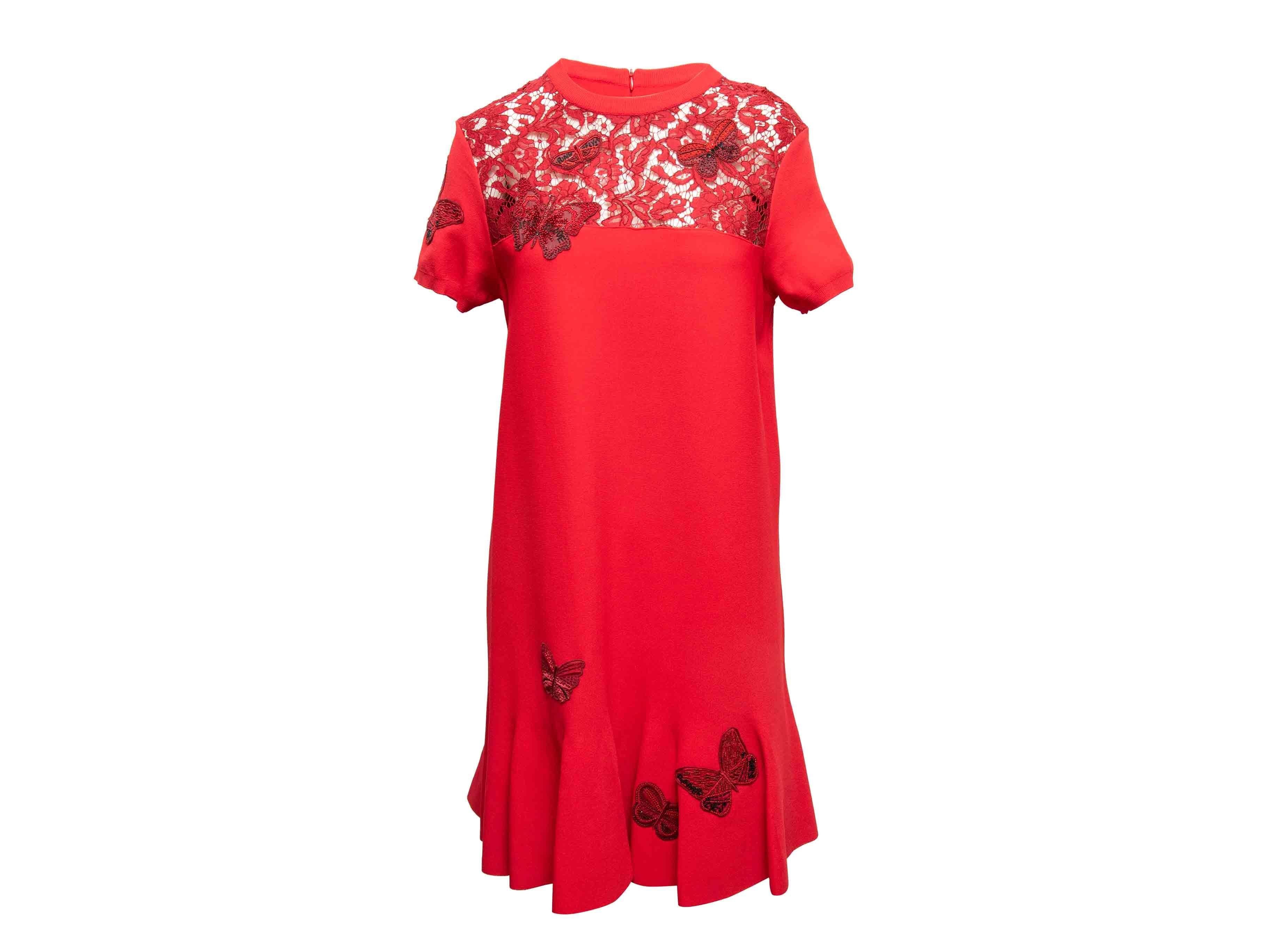 Abito rosso a manica corta con pizzo e motivo a farfalla di Valentino. Girocollo. Orlo a balze. Chiusura con zip sul retro. Seno 36
