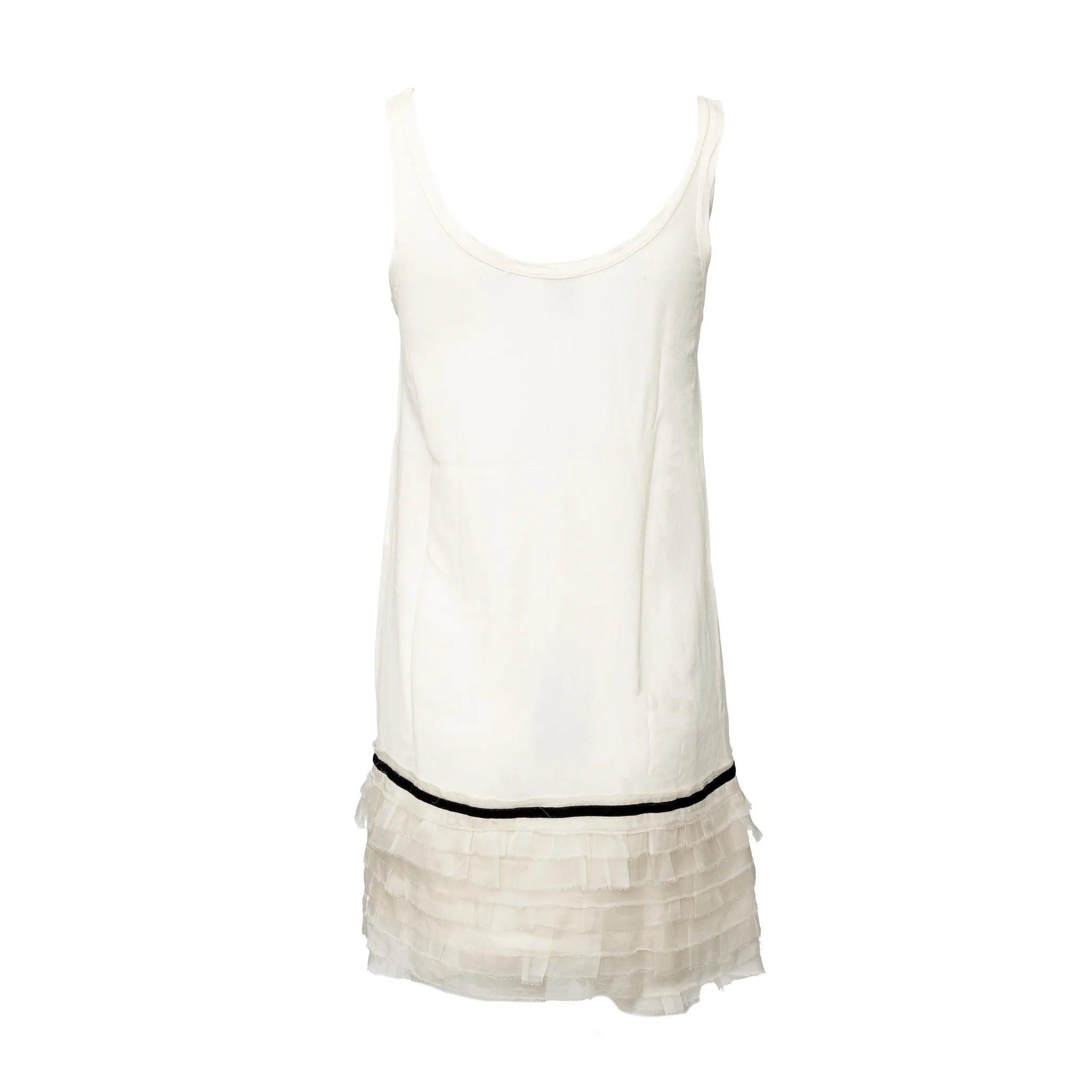 Minivestido de suave crepé de viscosa blanca con tirantes finos, pliegues con volantes en el bajo y un ribete de encaje de terciopelo negro para un acabado romántico y refinado.
 Observaciones: No hay etiqueta de talla.  
 Medidas: