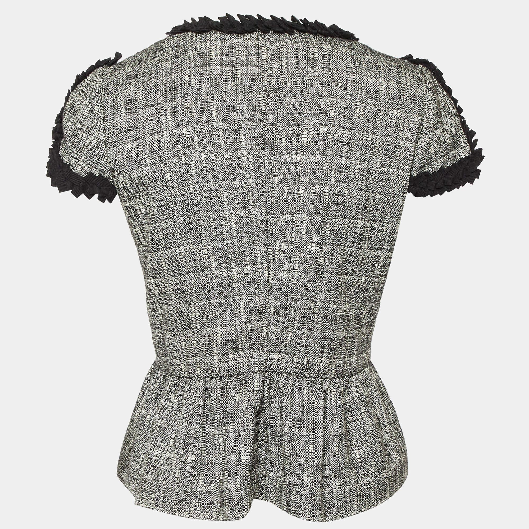 This RED Valentino monochrome tweed jacket is a chic blend of classic and contemporary style. Featuring delicate ruffle trim details it adds a feminine touch to the structured silhouette. Designed with a timeless appeal the jackets tweed fabric