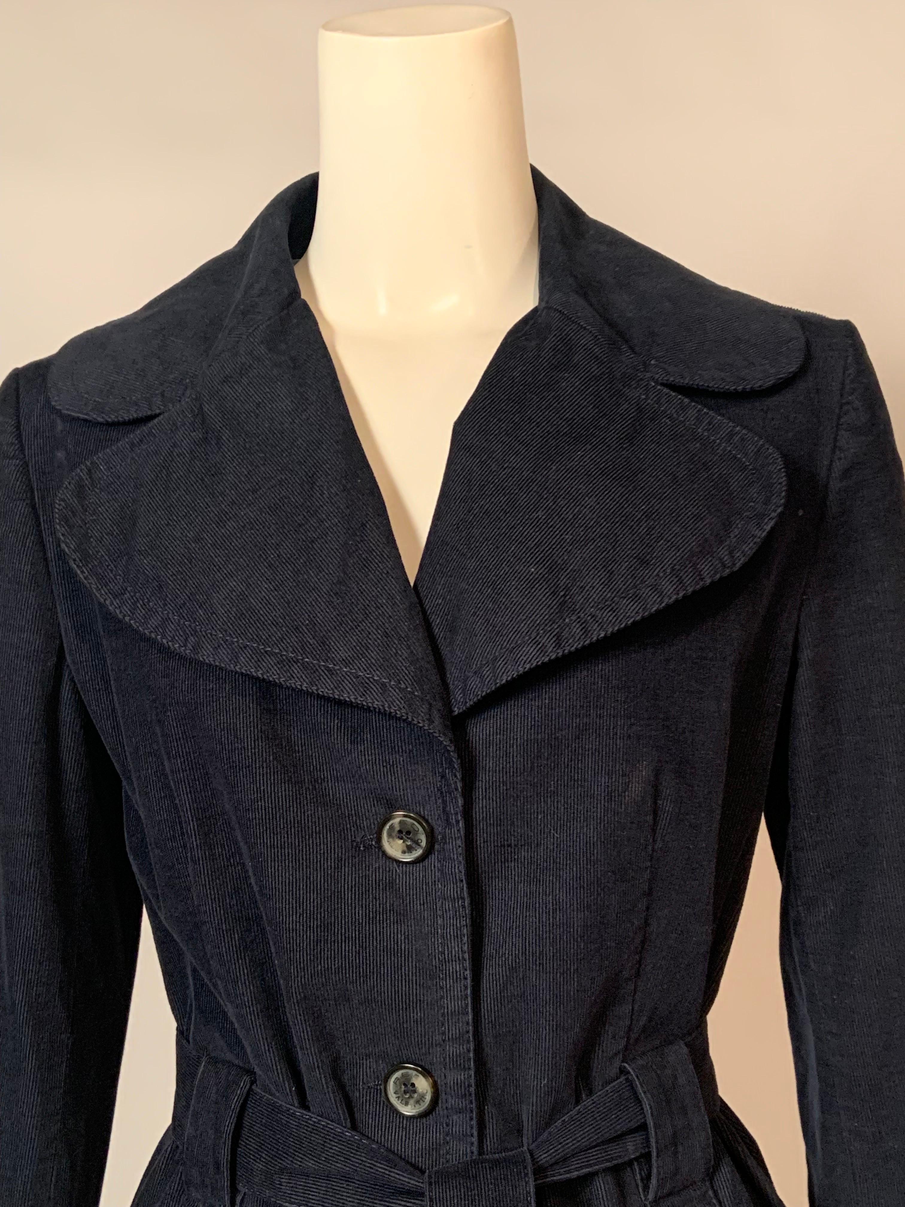This stylish jacket from R.E.D. Valentino is made from navy blue corduroy with a notched lapel, three button front, and a tie belt.  The patch pockets snap closed with a decorative silver tone V logo.  The jacket is fully lined in light blue