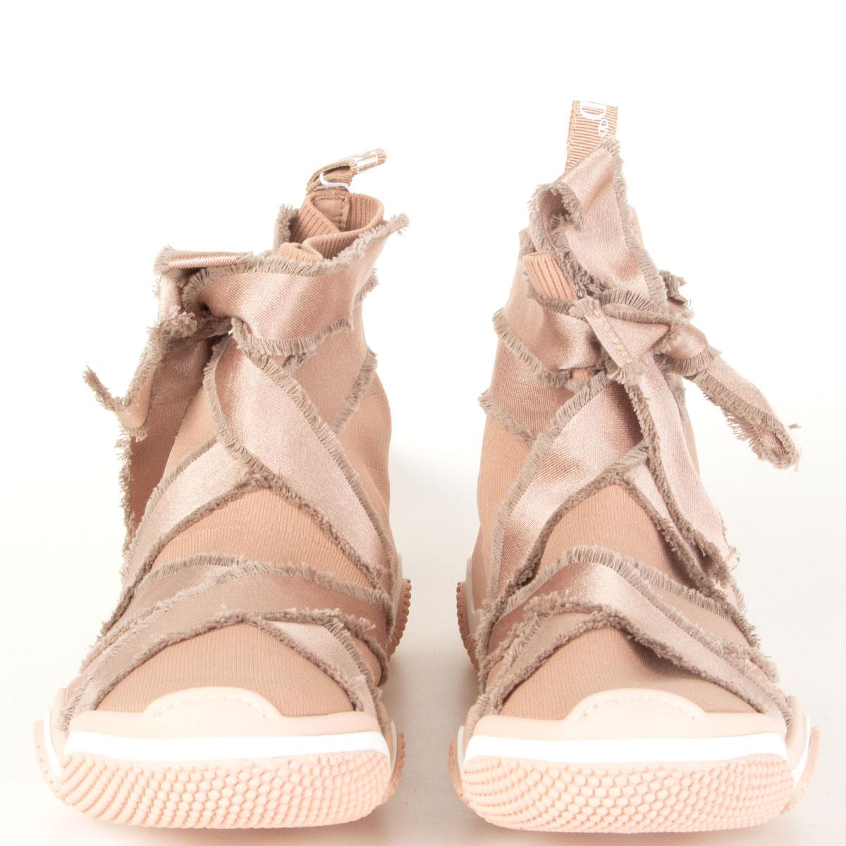RED by Valentino 'Glam Run' sock high-top sneakers in nude stretch knit with sleek fringed ribbons inspired by the traditional ballet shoe. Grosgrain ribbon with printed logo “REDV” on the heel. Lightweight and flexible rubber sole. Brand new. Come
