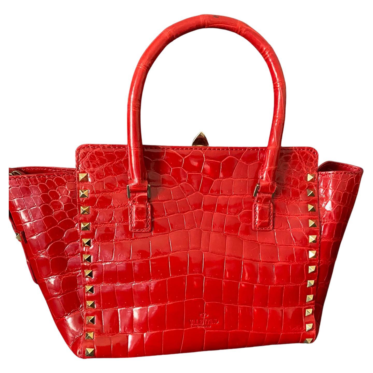 Red Valentino Rockstud bag in Mississipiensis crocodile. 
Gold hardware, zip closure. 
Provided with C.I.T.E.S. document issued by the maison Valentino.
 With shoulder strap. In very good condition. 
35 cm wide at the top and 23 cm at the bottom,