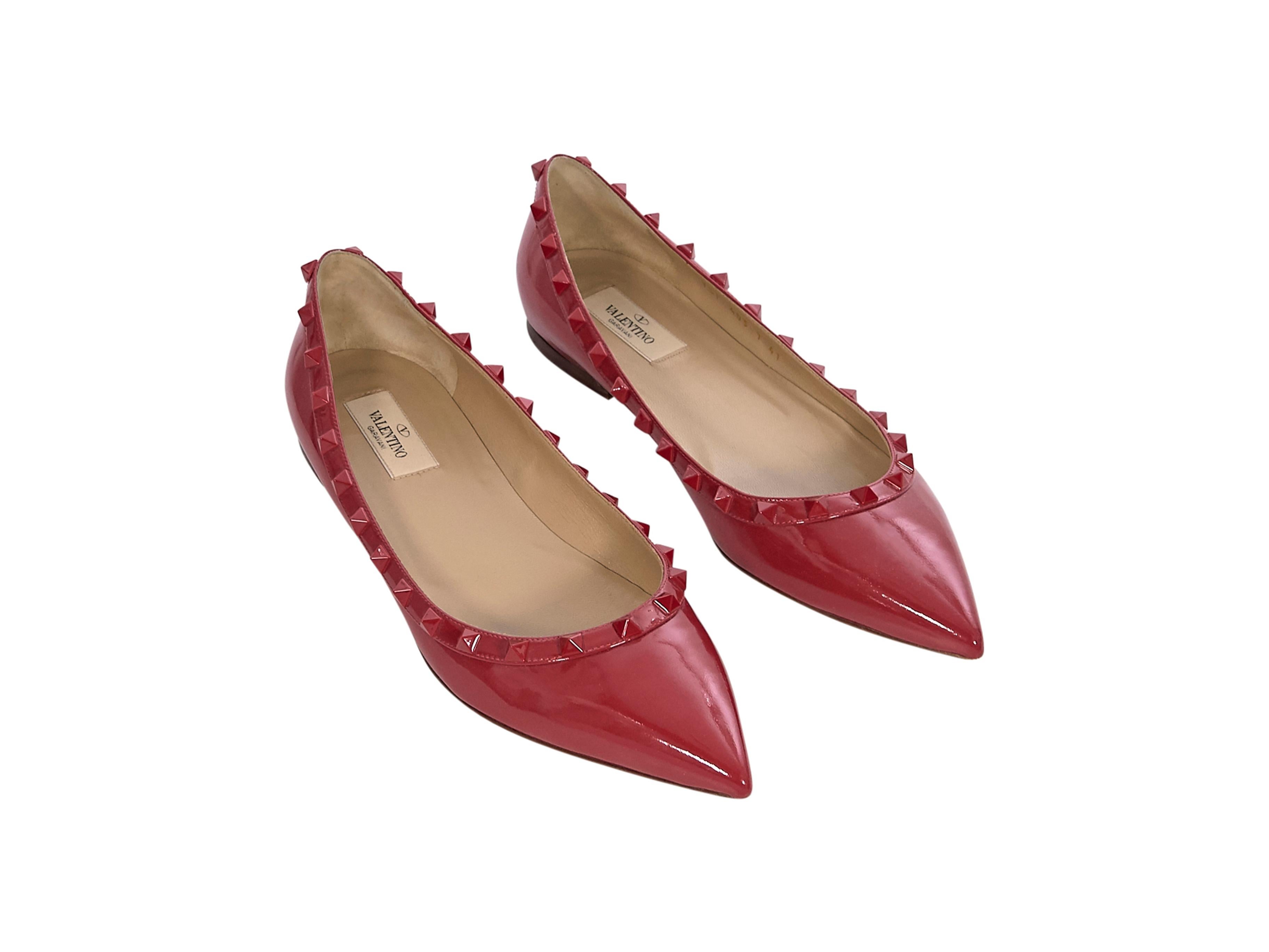 Product details: Red patent leather Rockstud flats by Valentino. Tonal stud-embellishments. Pointed-toe. Slip-on style. Brand size FR 41. Style with floral-patterned shorts. 