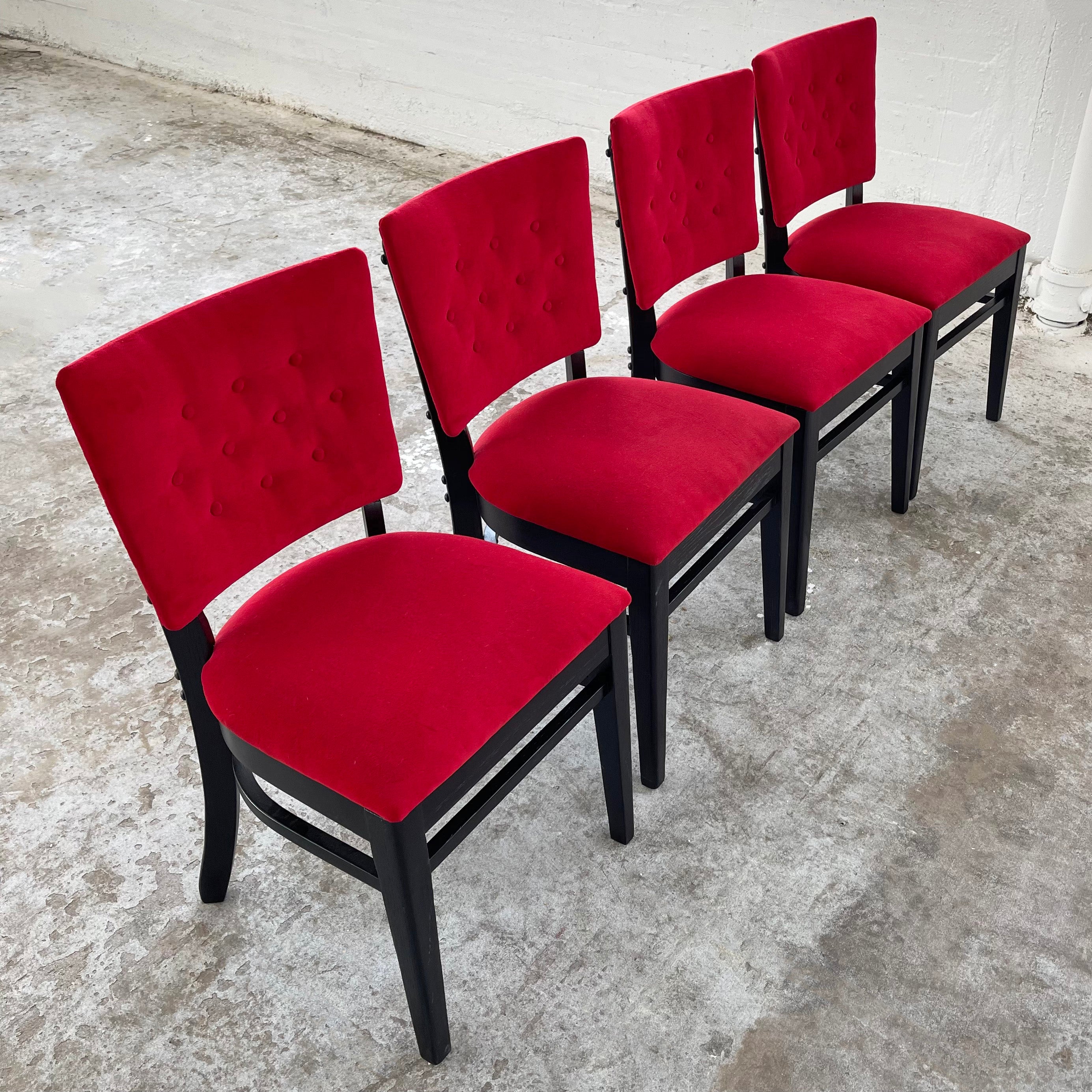 Set of four, mid-century, café bistro dining chairs circa 1940's feature vibrant red velvet upholstery with button tufted backs and ebonized oak frames. A bold color twist on these classic café chairs in sumptuous velvet. 