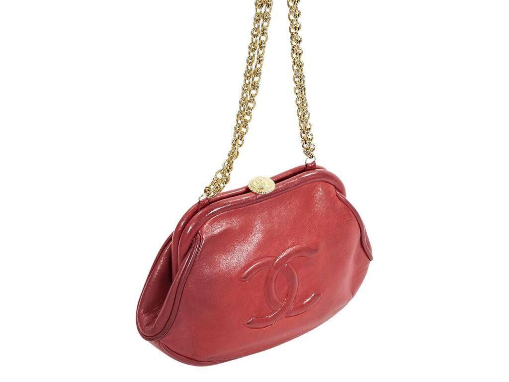 Product details:  Vintage red leather clutch by Chanel.  Embossed logo front.  Tuck-away chain shoulder straps.  Top push-lock closure.  Leather interior with zip pocket.  Goldtone hardware.  Authenticity card and dust bag included.  8