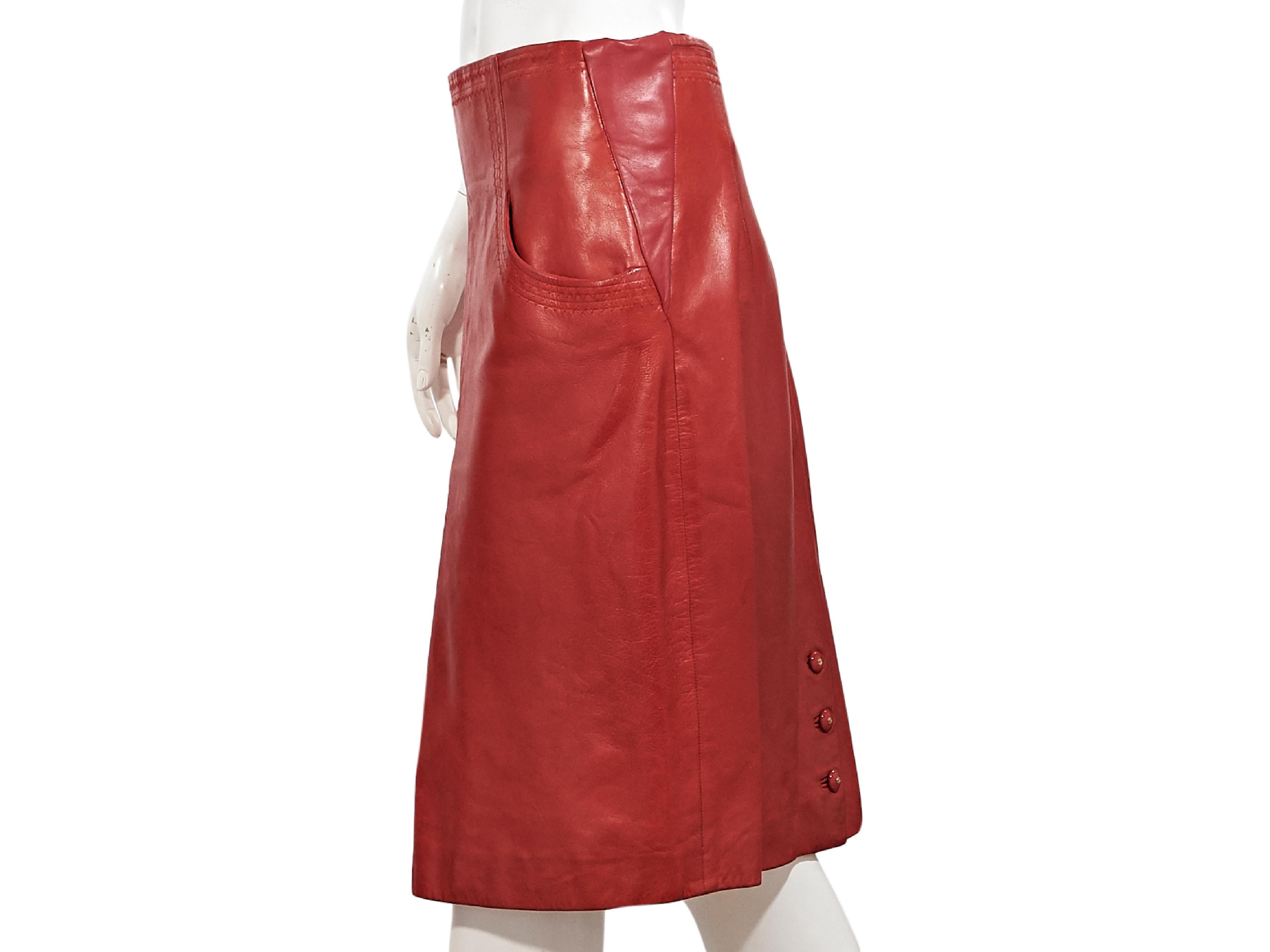 Product details:  Vintage red leather pencil skirt by Chanel.  Accented with tonal topstitching.  Waist scoop pockets.  Back zip closure.  Center back hem vent with triple-button detail.  34