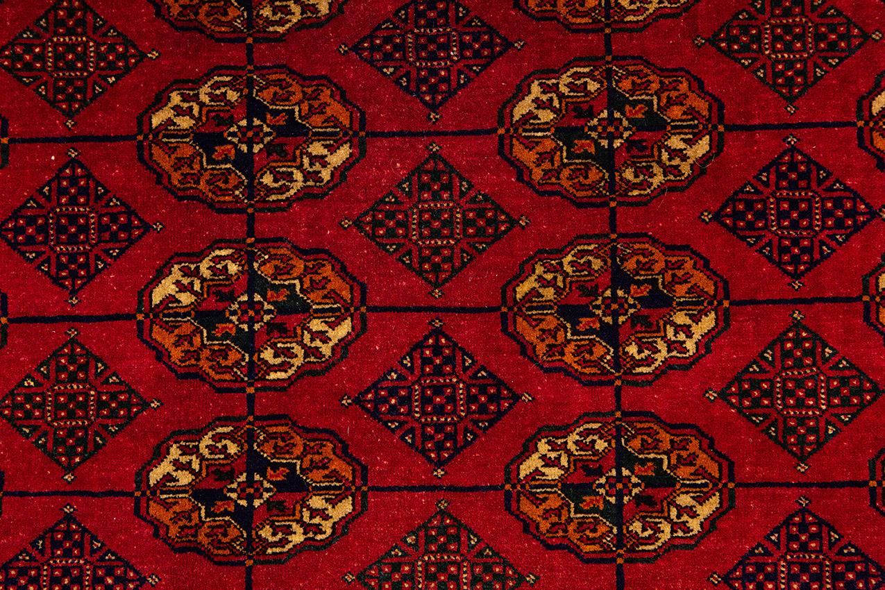 This Red vintage Bukara rug is perfect for adding a touch of elegance to any room. It's made with high-quality materials and craftsmanship, and it's sure to last for many years. The red color is rich and vibrant, and it will add a pop of color to