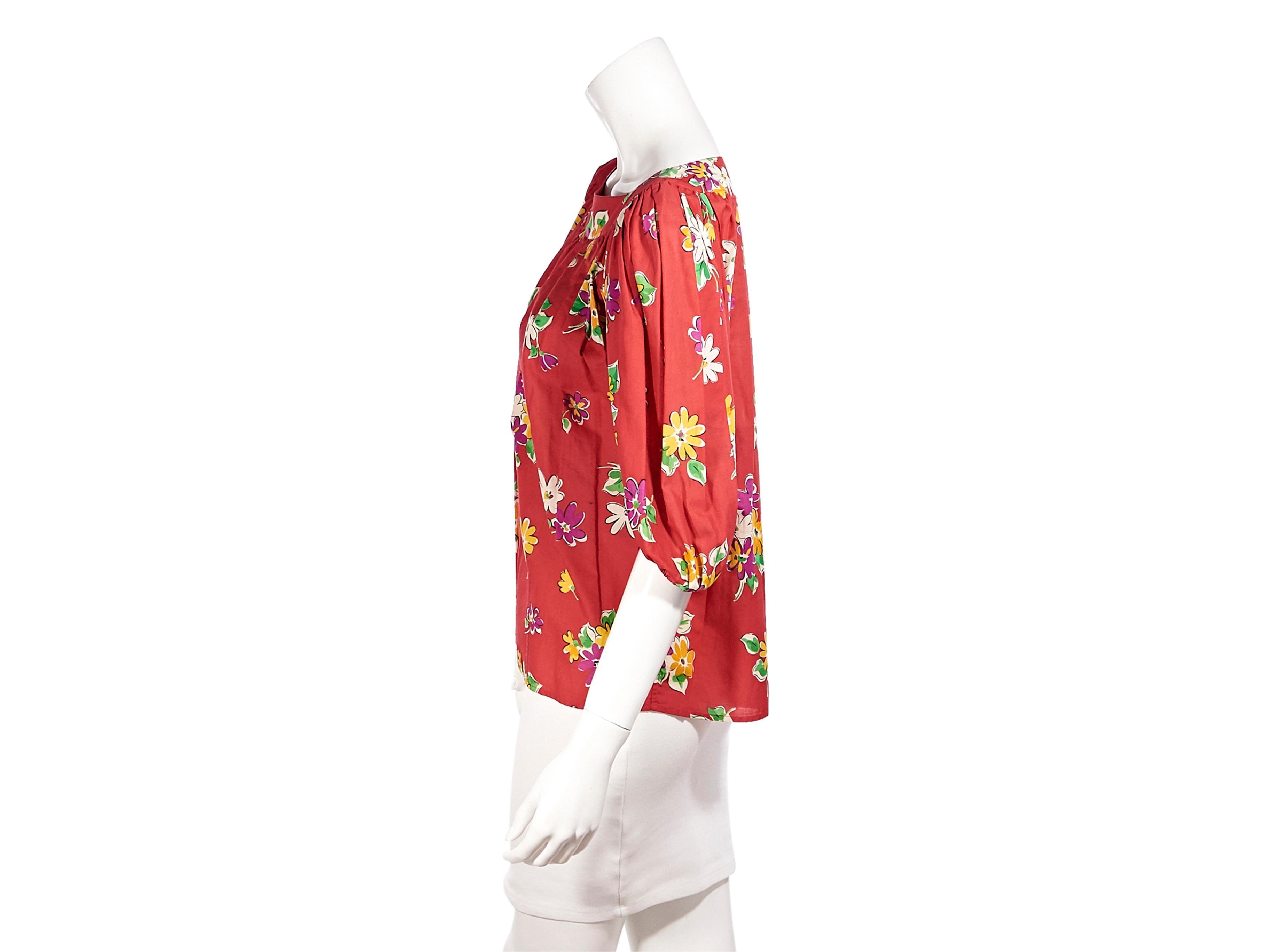 Product details:  Vintage red floral-printed blouse by Saint Laurent Rive Gauche. Bateau neckline. Puff shoulder dolman sleeves. Elasticated-trimmed cuffs. Slip-on style. Pair yours with denim shorts. Label size FR 38. 40