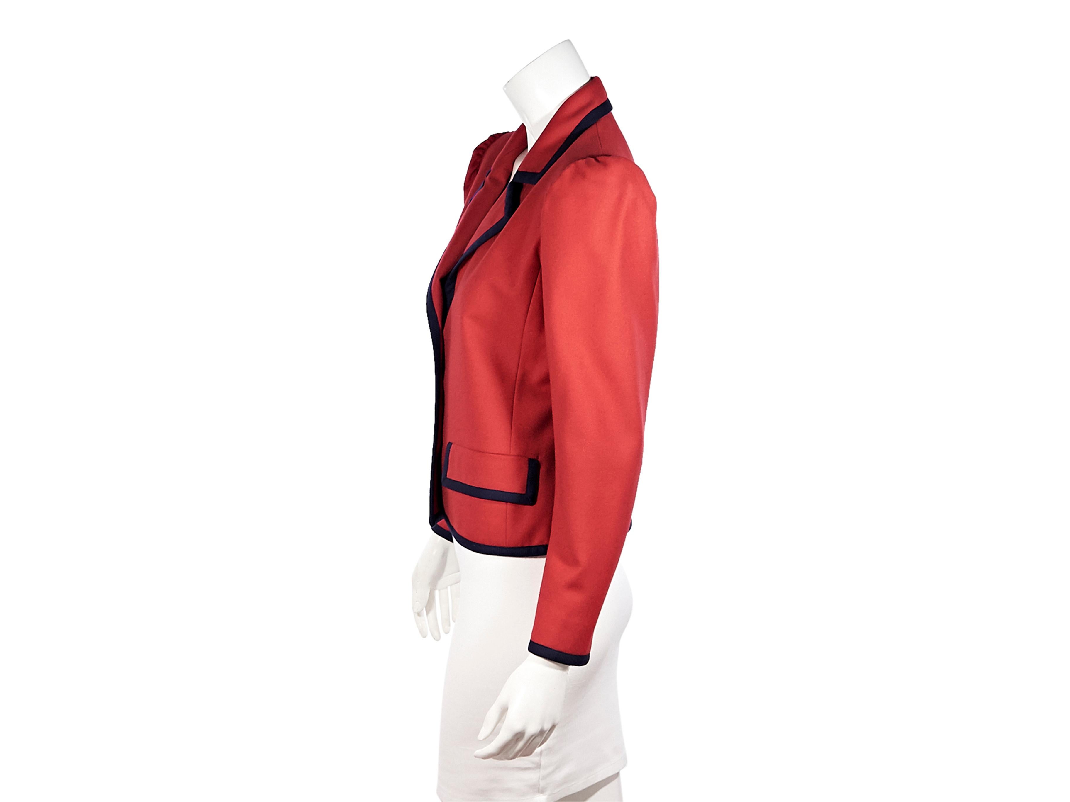 Product details:  Vintage red wool jacket by Saint Laurent.  Circa the 1970s/80s. Contrast navy trim.  Peak lapels.  Long sleeves.  Button-front closure.  Two front flap pockets. Wear layered over a white T-shirt for a modern look. Label size FR 40.