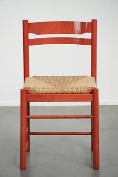 Chaise vintage rouge en bois des années 1970 avec une assise en osier tressé.