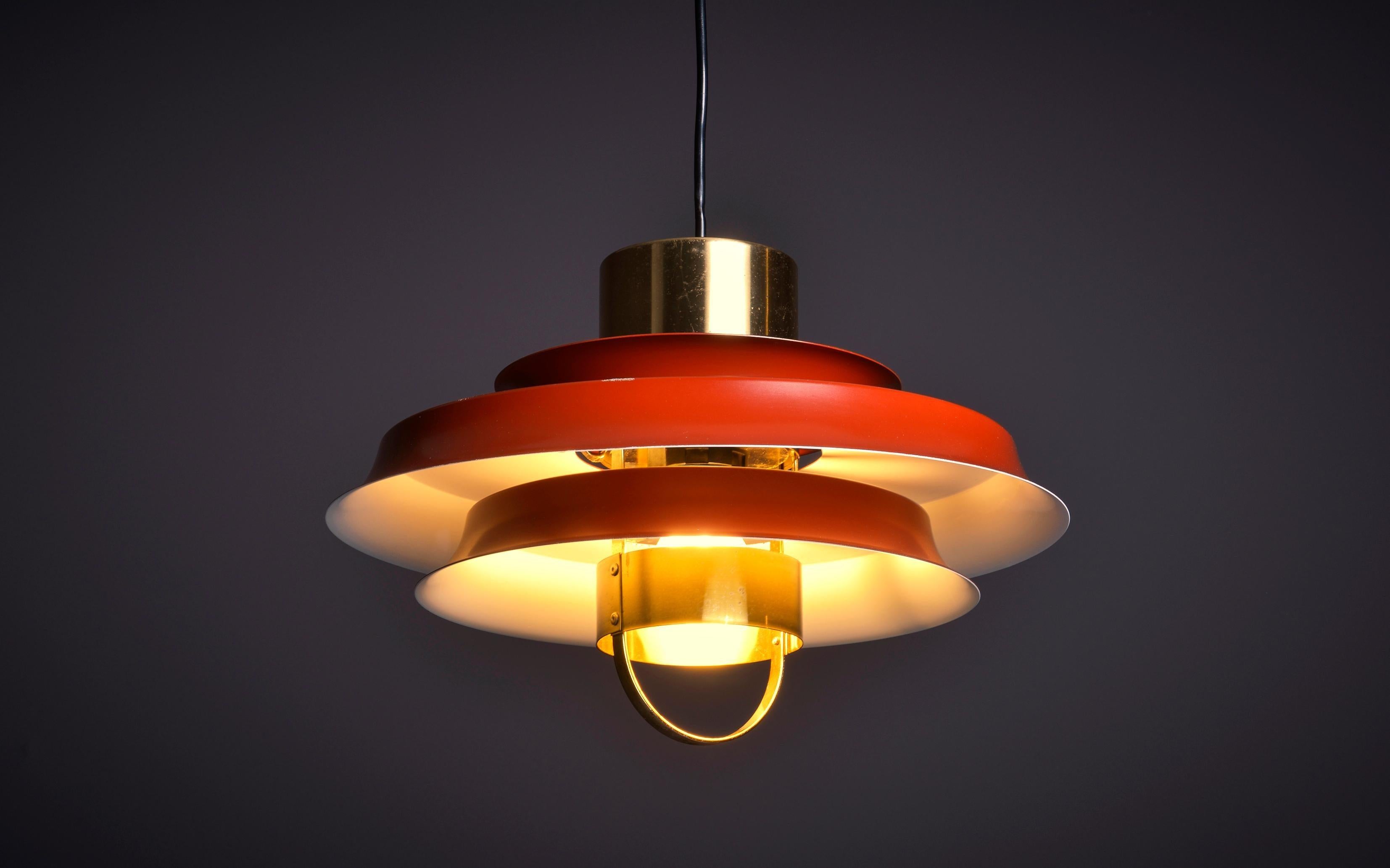 Pendant lamp in red lacquered aluminum and brass elements by Danish manufacturer Vitrika , 1970s. Socket: 1 x E27.

Danish lighting manufacturer Vitrika was founded in the 1940s with a focus on three main elements being retail, design and