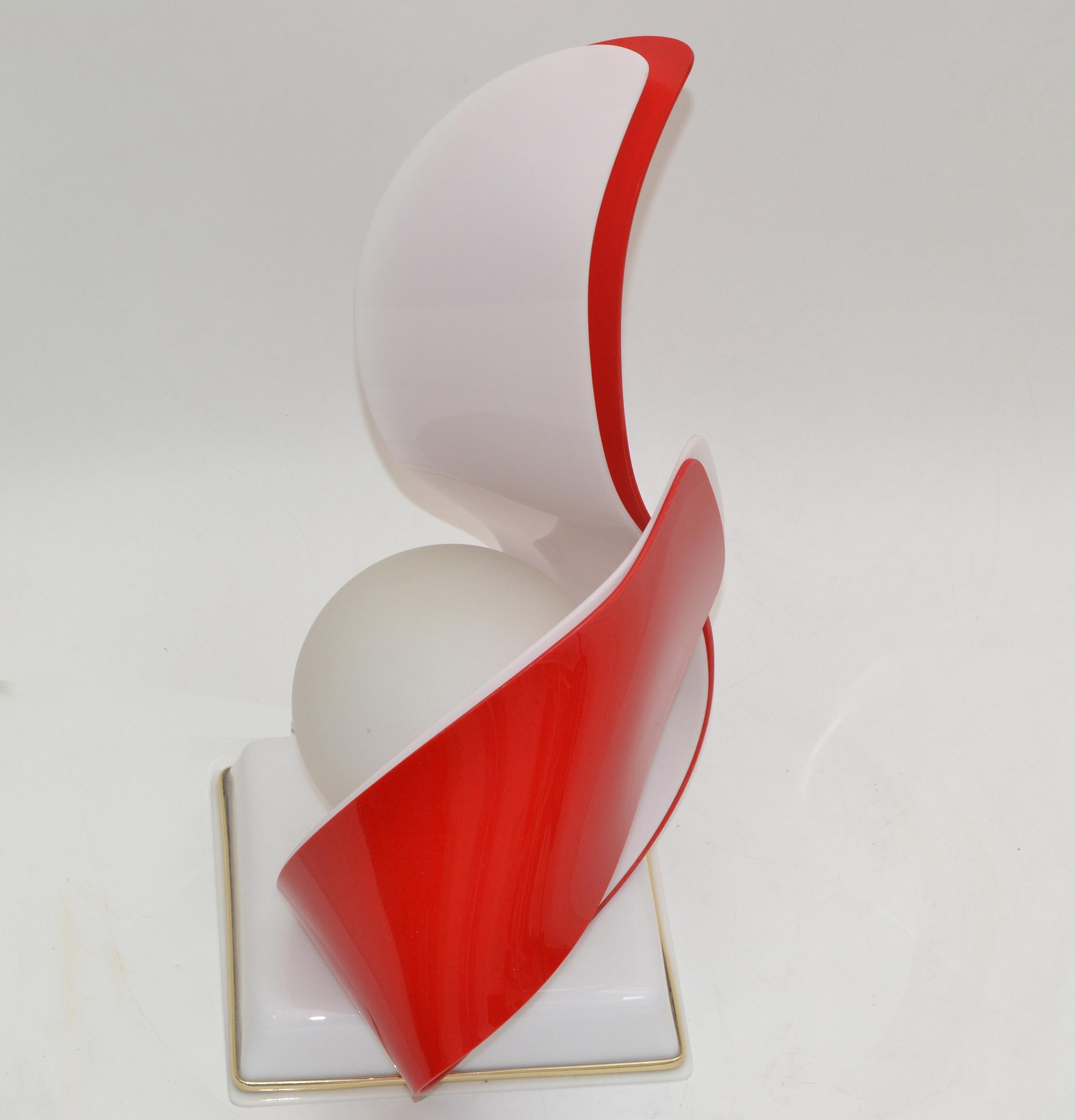 Mid-Century Modern red & white acrylic sculptural table lamp by acrylic designs.
The Lamp has a milk glass globe and takes one max. 40 watts light bulb.
In perfect working condition, wired for the U.S. and has a cord switch.
 