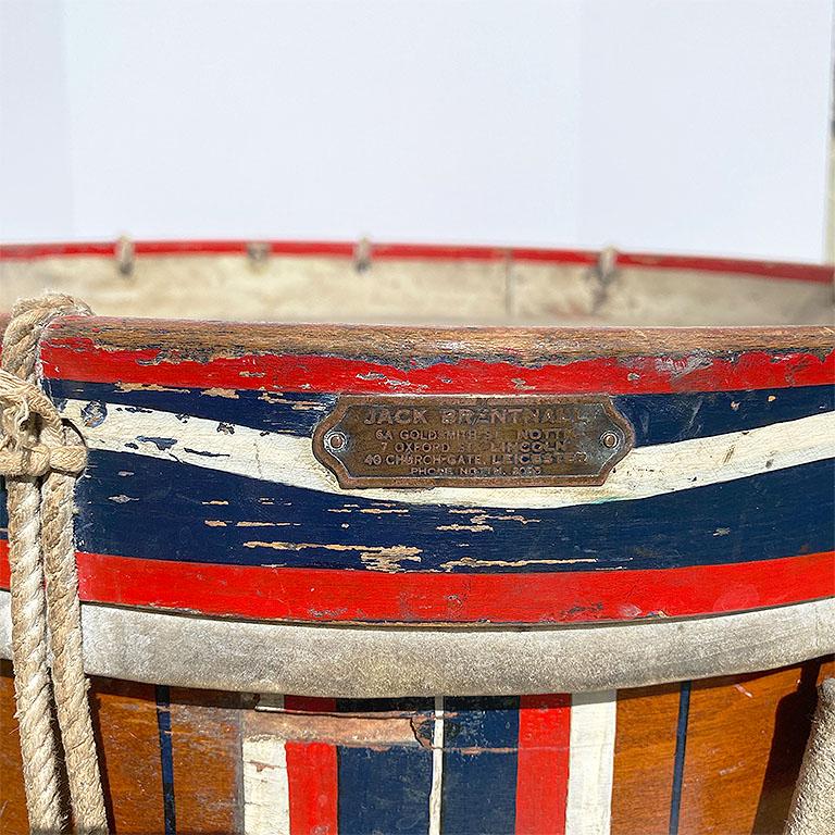 Important British drum by Jack Brentnall. In red, white, and blue, this lovely piece stands on a custom created stand making it perfect for use as a side table. The original plaque is intact and affixed to the side near the top. Ropes are tied in a