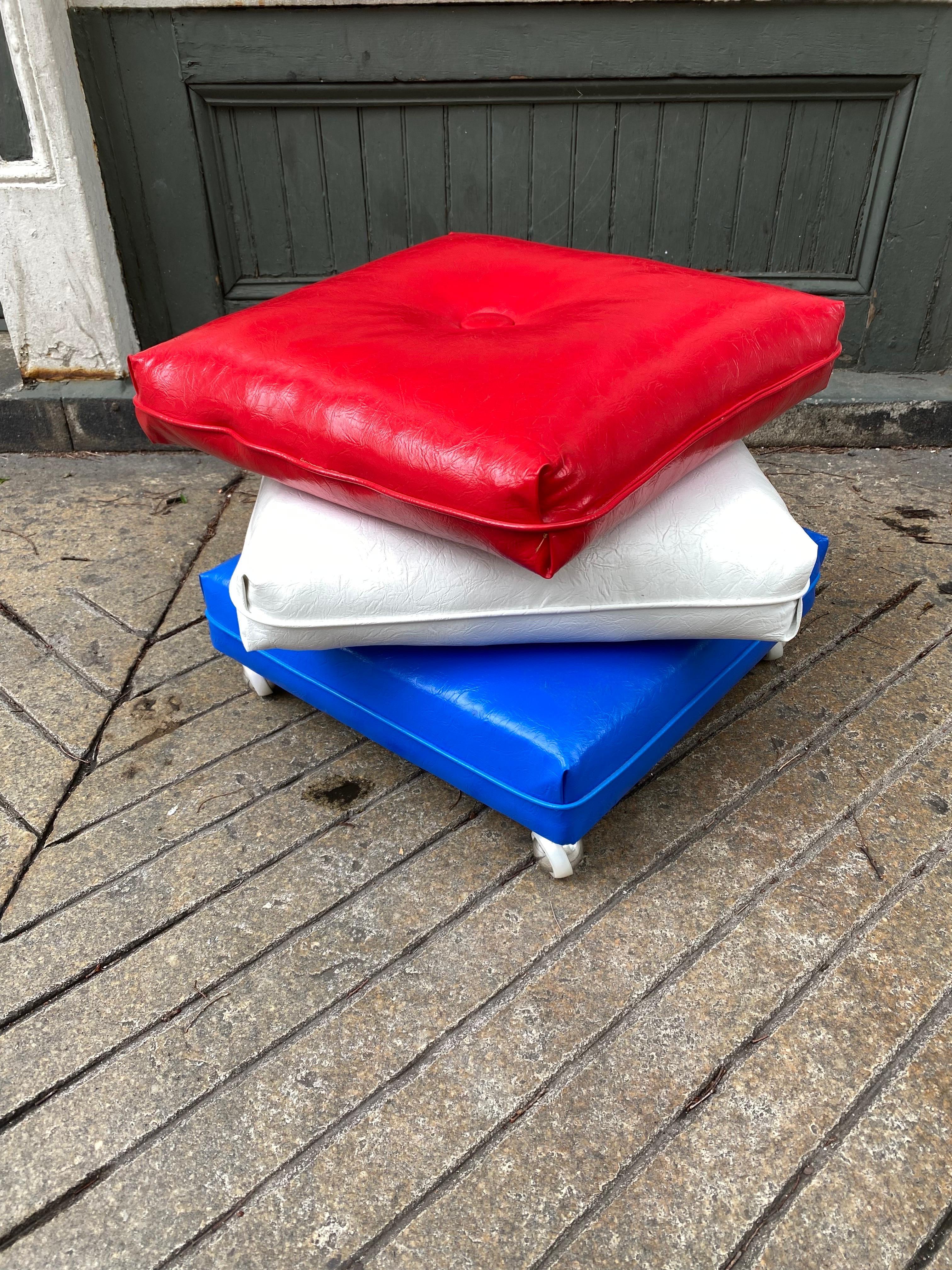 Red, White and Blue Stacked Pillows Ottoman on Wheels. In very nice Original condition! Vinyl is very clean! Bottom Pillow has casters so ottoman moves easily! Great period piece in great unrestored condition!