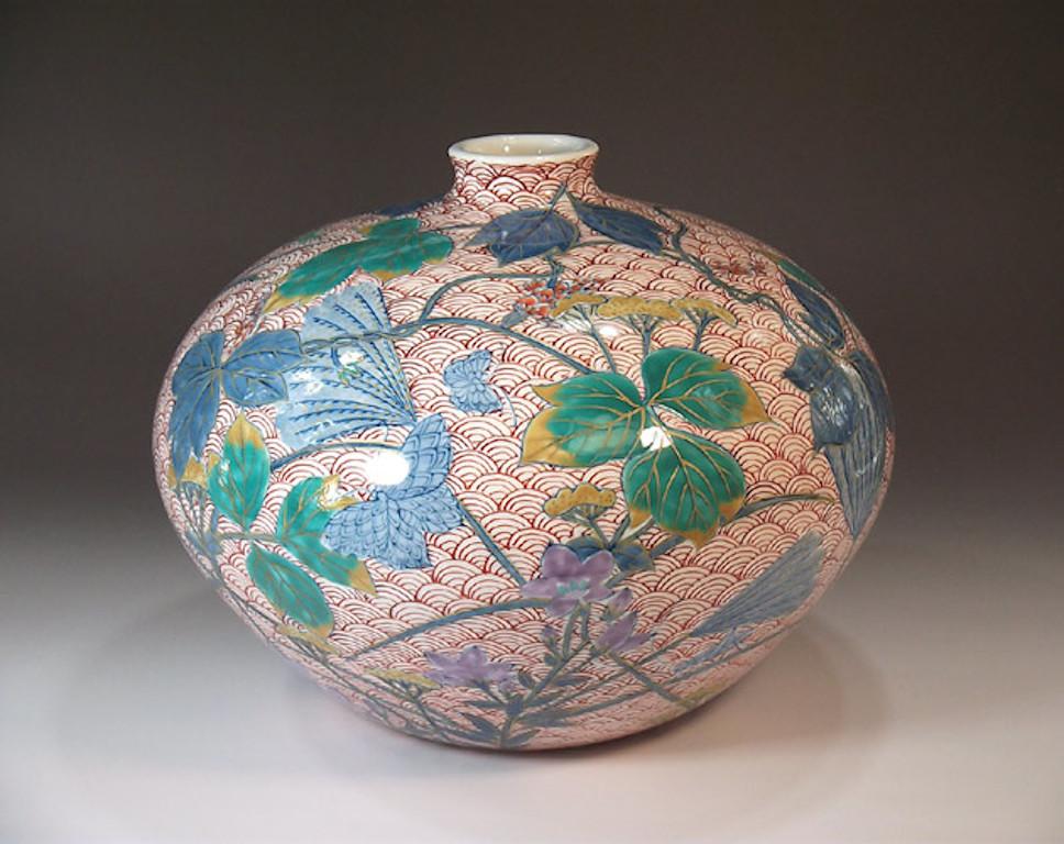 Elegant Japanese decorative porcelain vase, intricately hand painted on an ovoid body in iron-red and rich blue and green, a signed work by highly acclaimed master porcelain artist and the recipient of numerous prestigious awards for his